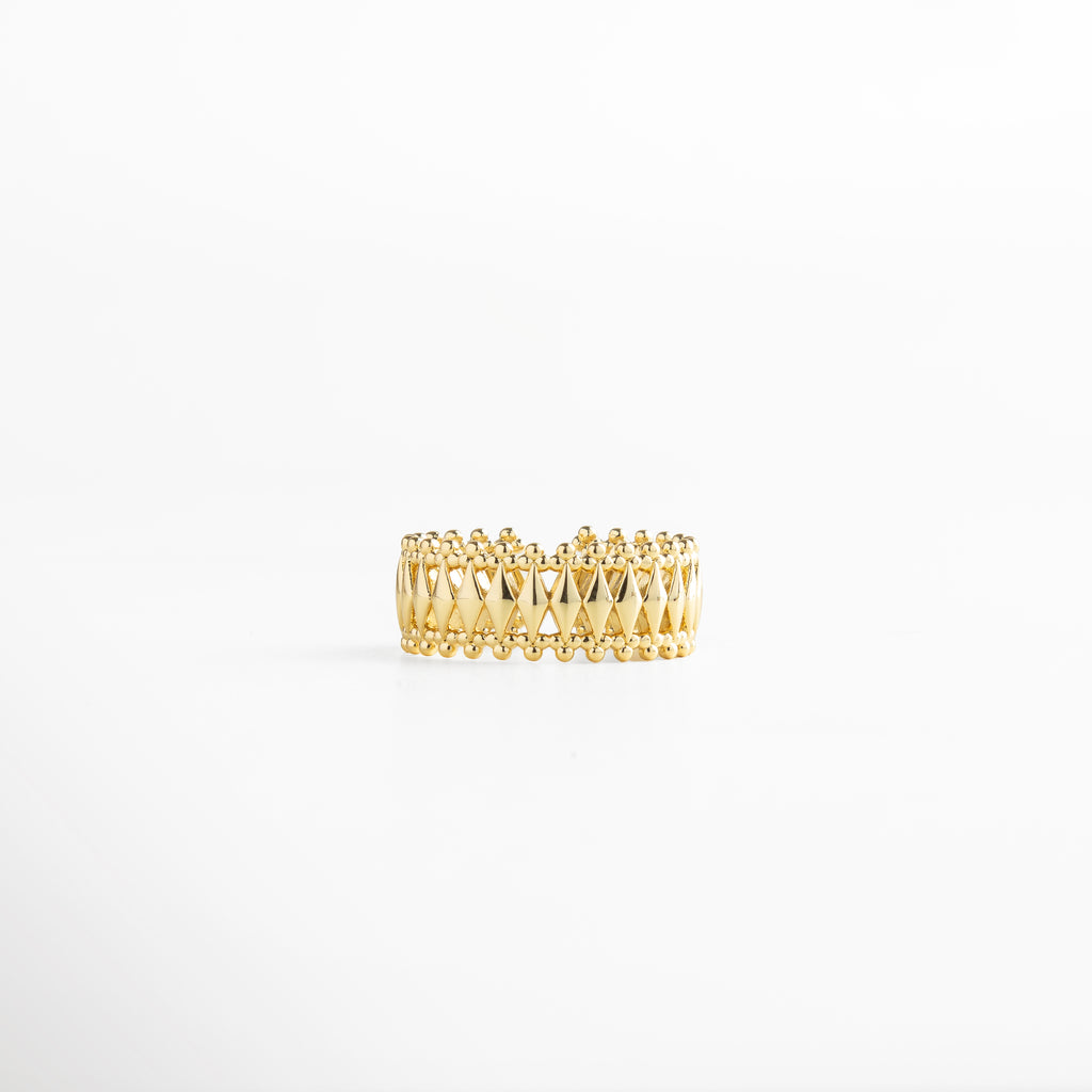 Anillo dorado con patrón geométrico entrelazado y bordes de esferas, recubrimiento en oro 18K, diseño ancho de 0.8 cm ajustable y elegante.