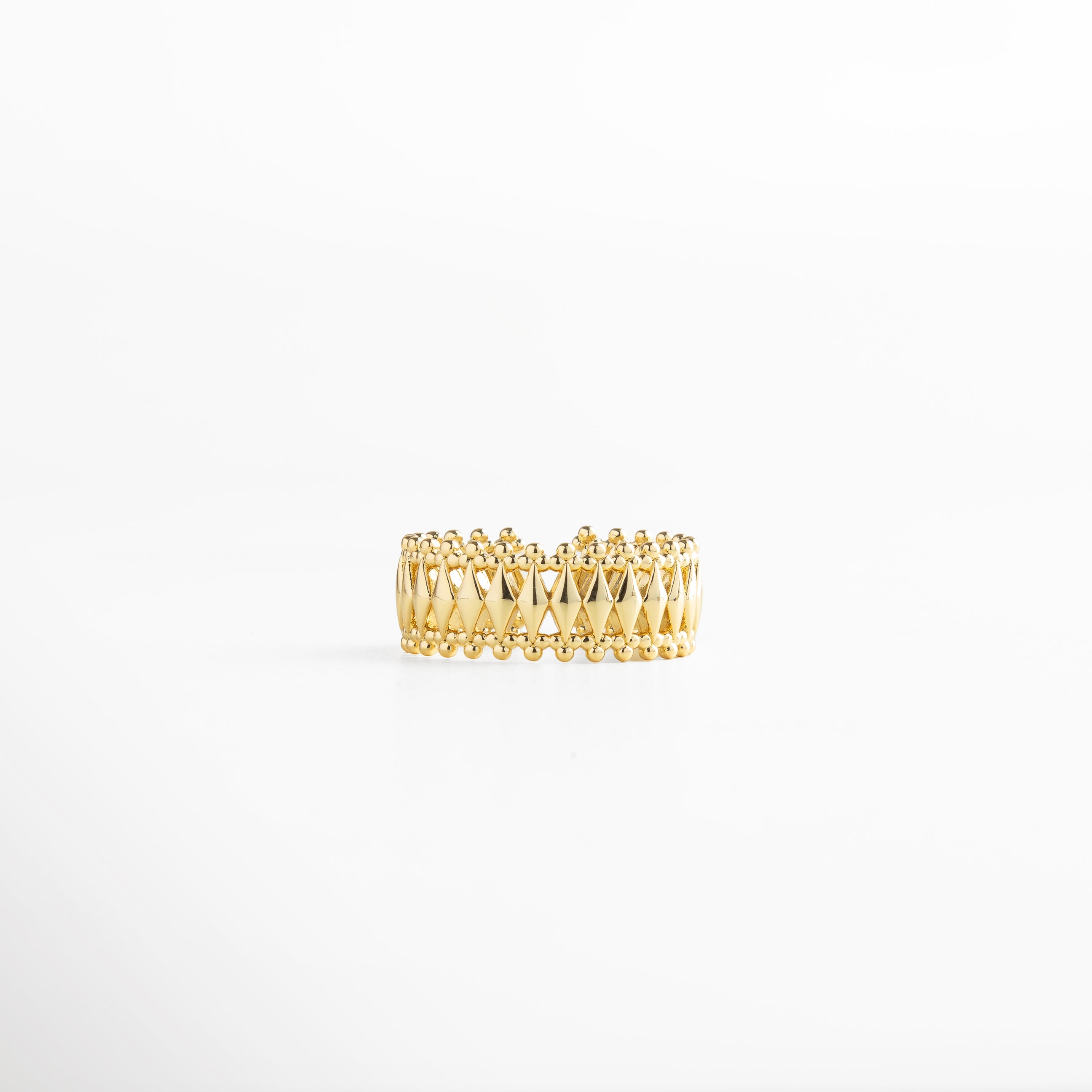 Anillo dorado con patrón geométrico entrelazado y bordes de esferas, recubrimiento en oro 18K, diseño ancho de 0.8 cm ajustable y elegante.