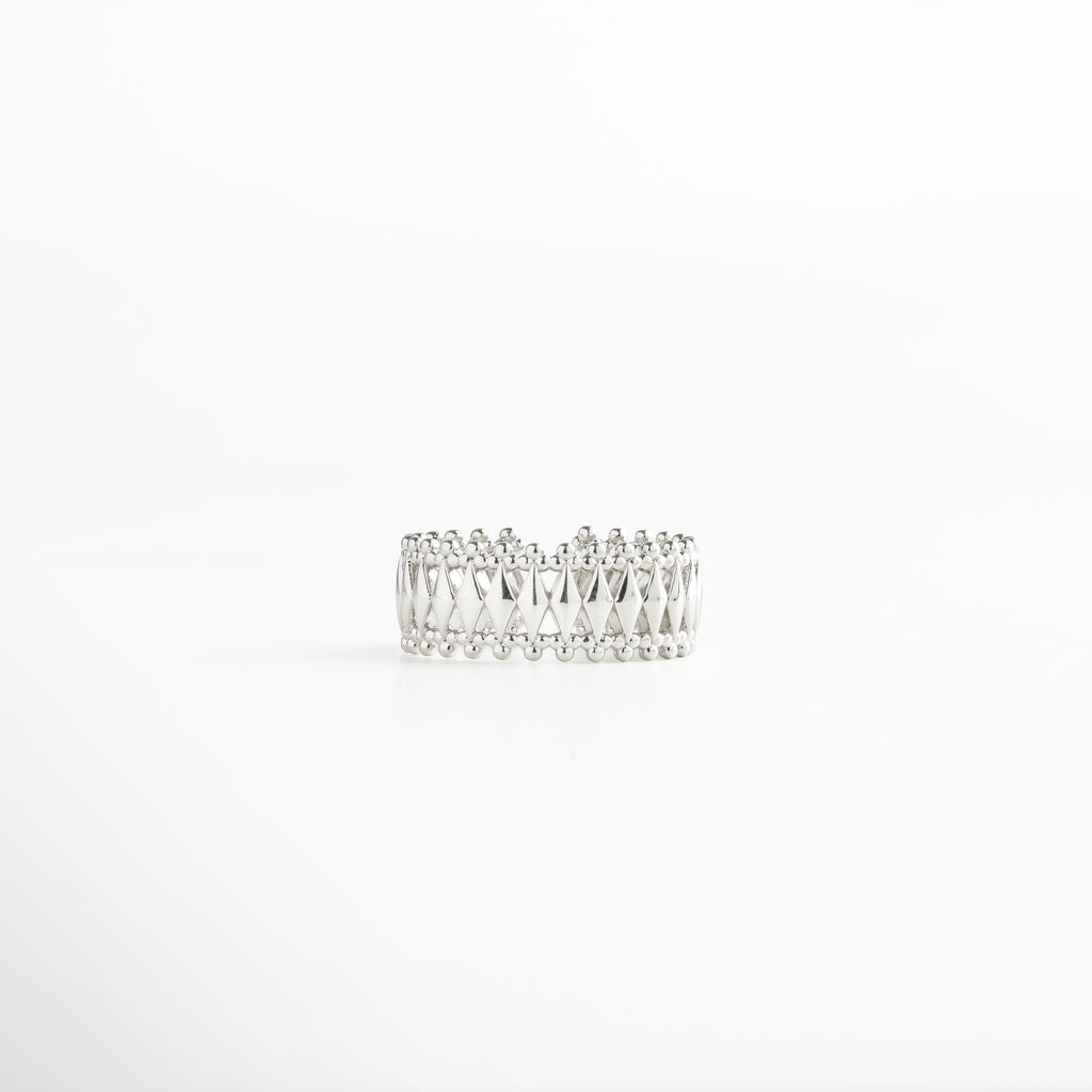 Anillo en plata con patrón geométrico entrelazado y bordes de esferas, acabado en oro blanco 18K, diseño ancho de 0.8 cm ajustable y elegante.