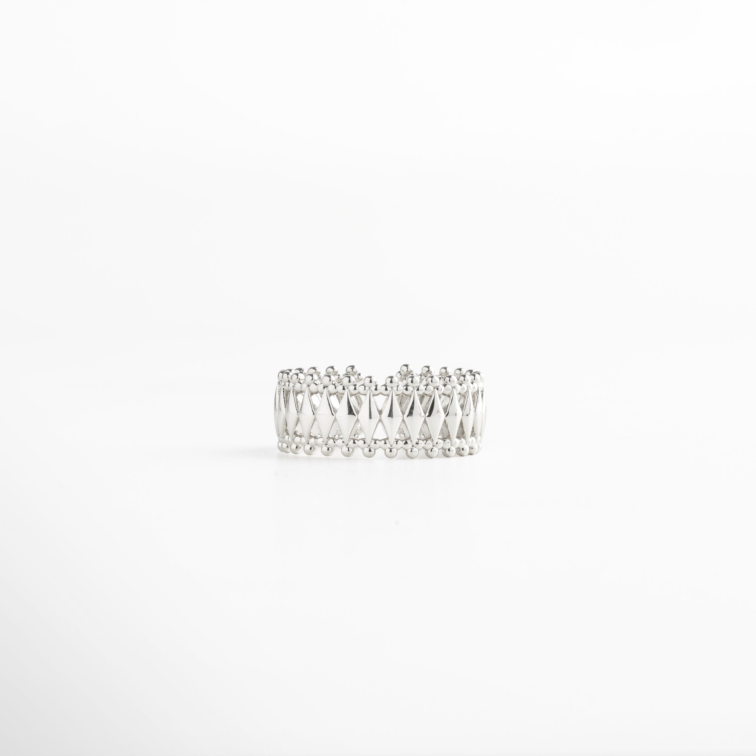 Anillo en plata con patrón geométrico entrelazado y bordes de esferas, acabado en oro blanco 18K, diseño ancho de 0.8 cm ajustable y elegante.