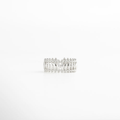 Anillo en plata con patrón geométrico entrelazado y bordes de esferas, acabado en oro blanco 18K, diseño ancho de 0.8 cm ajustable y elegante.
