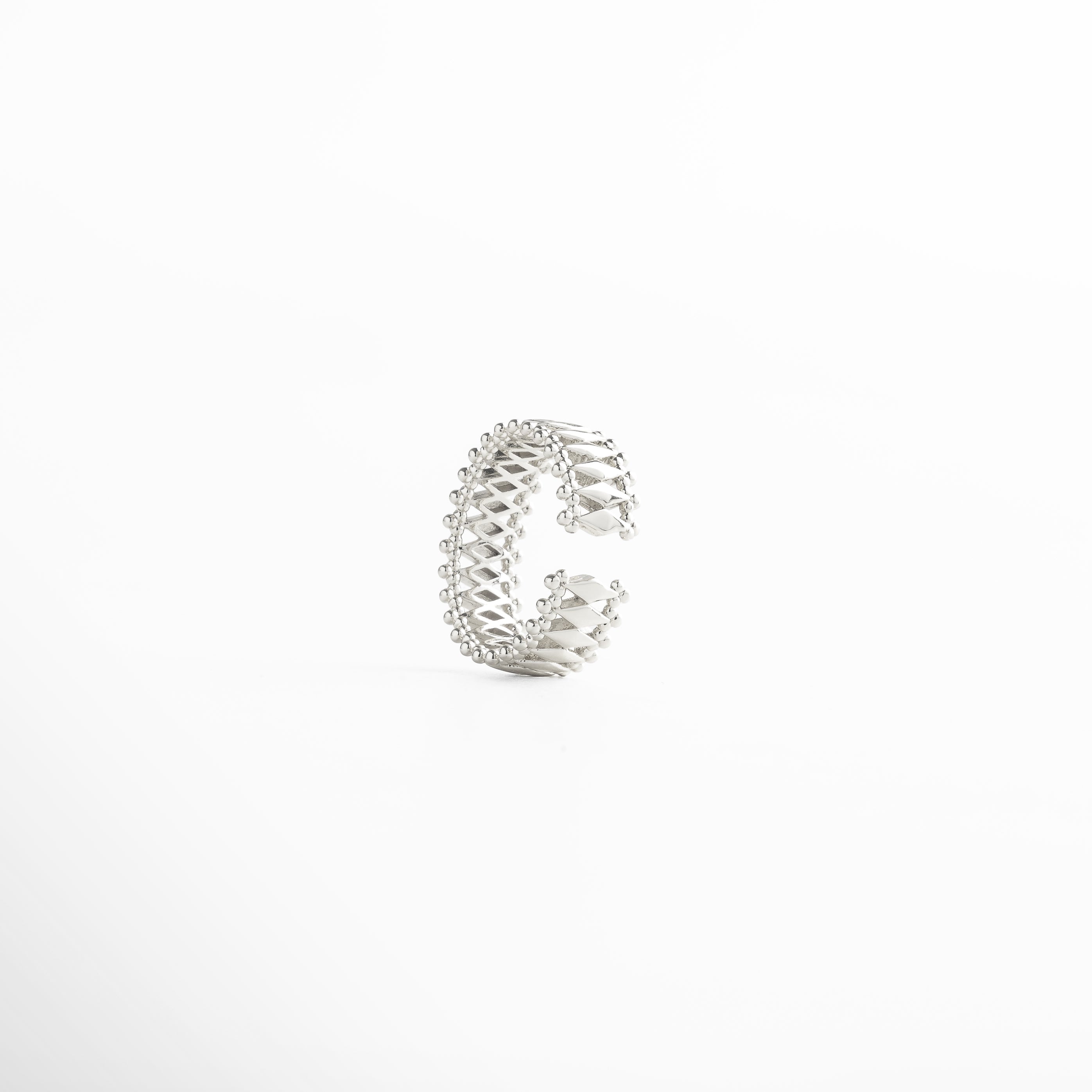 Anillo de cobre bañado en oro blanco 18K con diseño moderno de entramado y textura de esferas, pieza atemporal y versátil para looks casuales o formales.