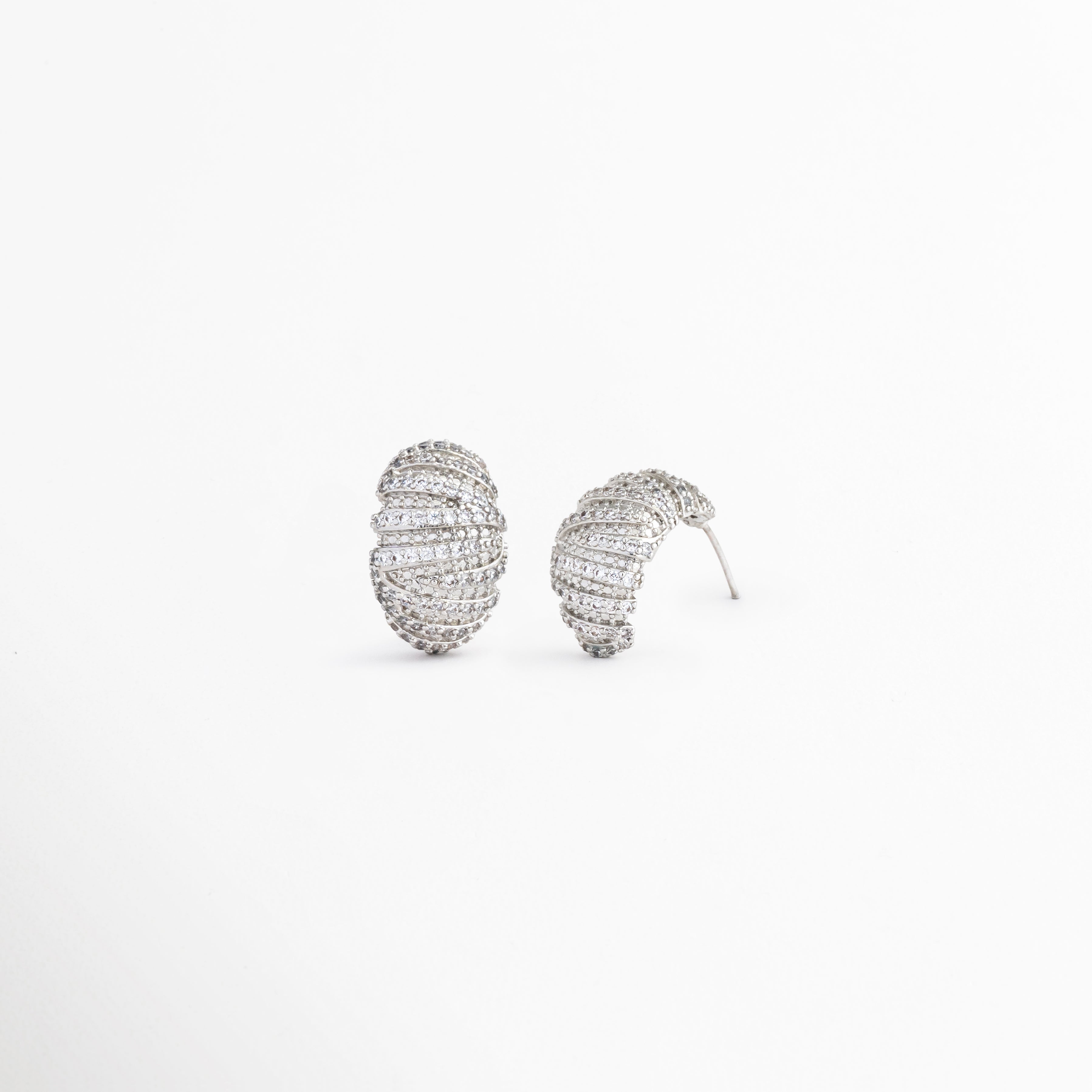 Vista inclinada de aretes Silver Mila con acabado brillante, Pendientes ovalados con zirconias y diseño contemporáneo, Detalle de aretes plateados con textura y brillo sutil, Aretes elegantes para mujer con incrustaciones de zirconia, Vista complementaria de pendientes Silver Mila con acabado premium.