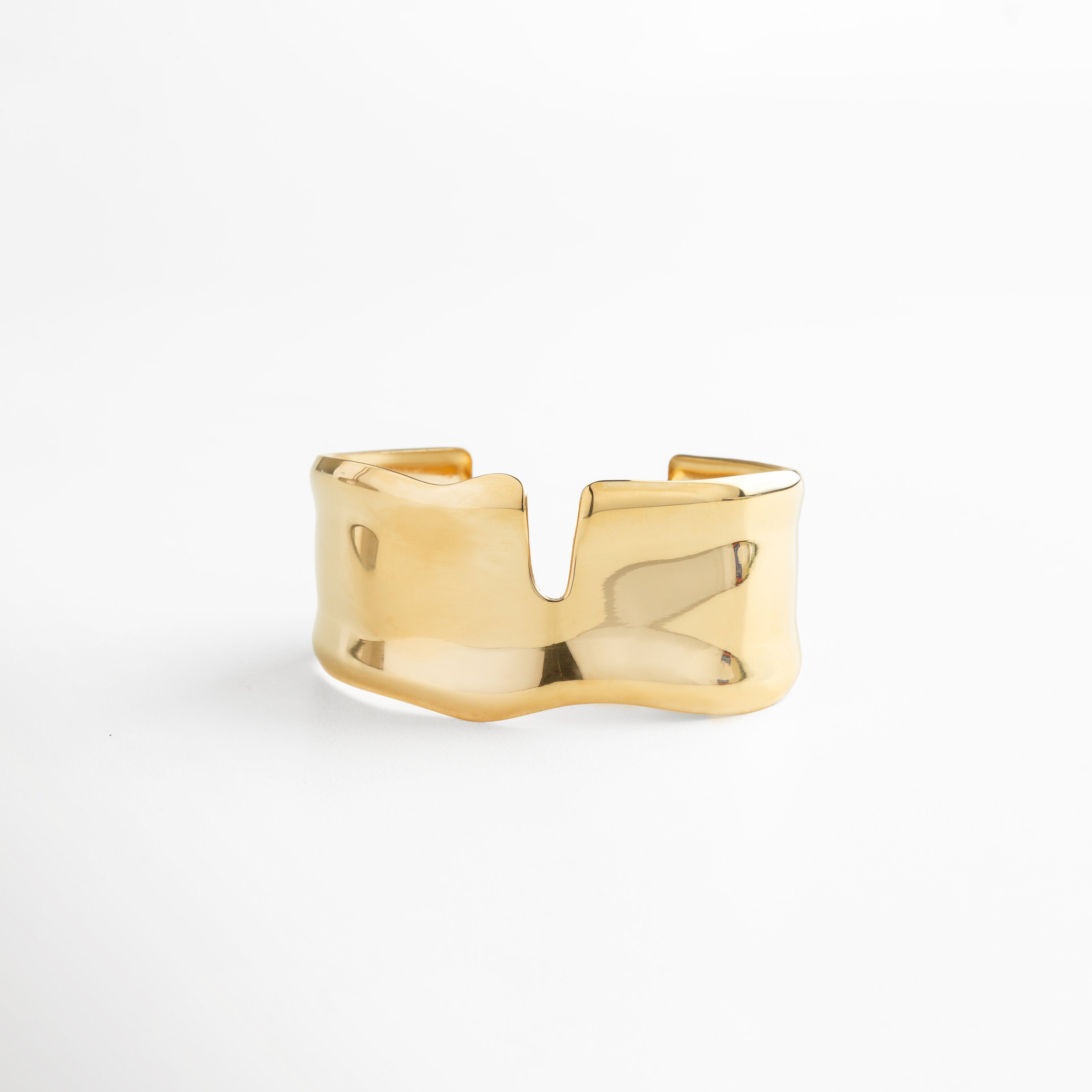 Pulsera ancha dorada de acero inoxidable con acabado pulido en oro 18K, diseño minimalista y voluminoso tipo statement, ideal para un look moderno y sofisticado.