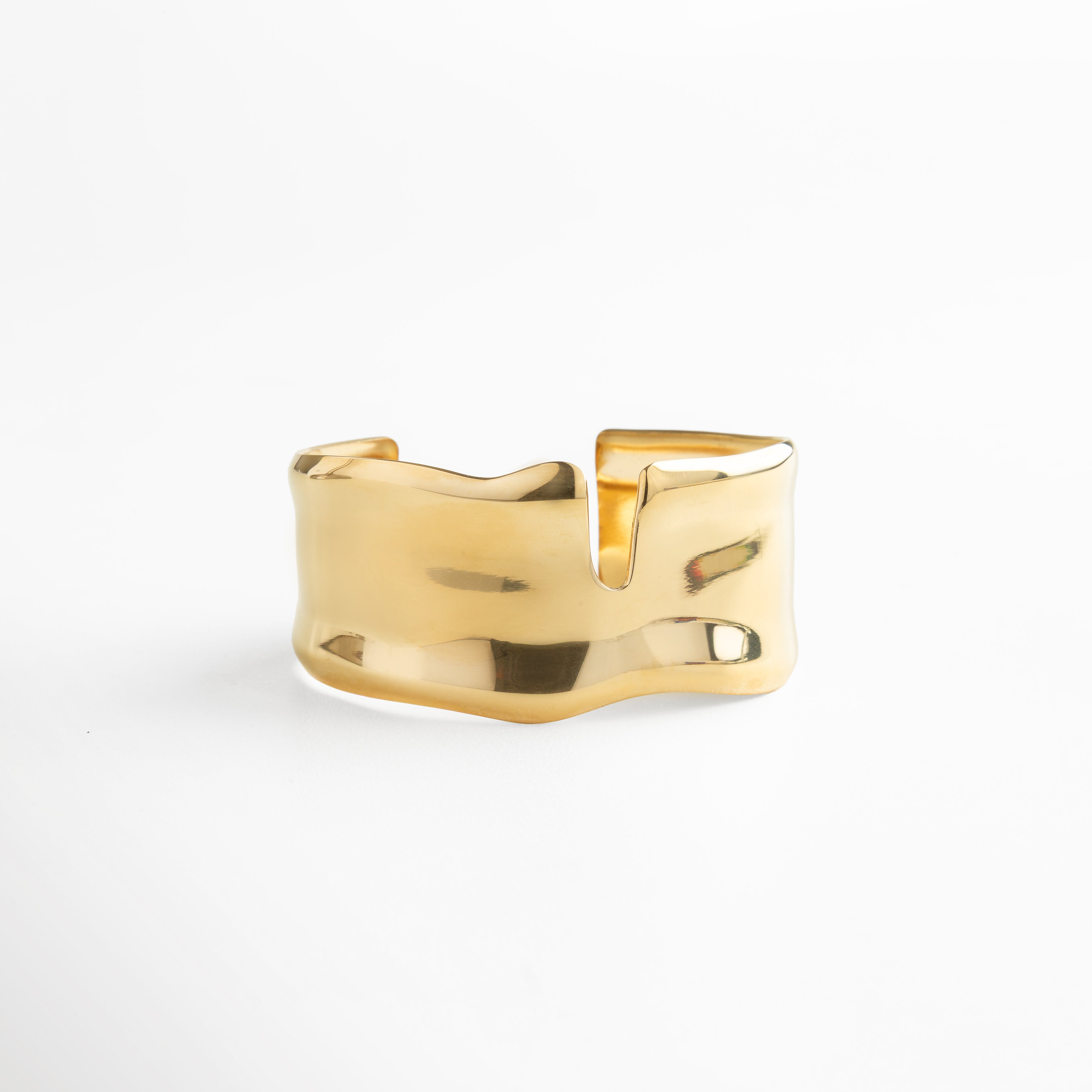 Brazalete dorado ancho con acabado brillante y corte geométrico, pieza minimalista en oro 18K sobre acero inoxidable, moderna y versátil para elevar cualquier outfit.