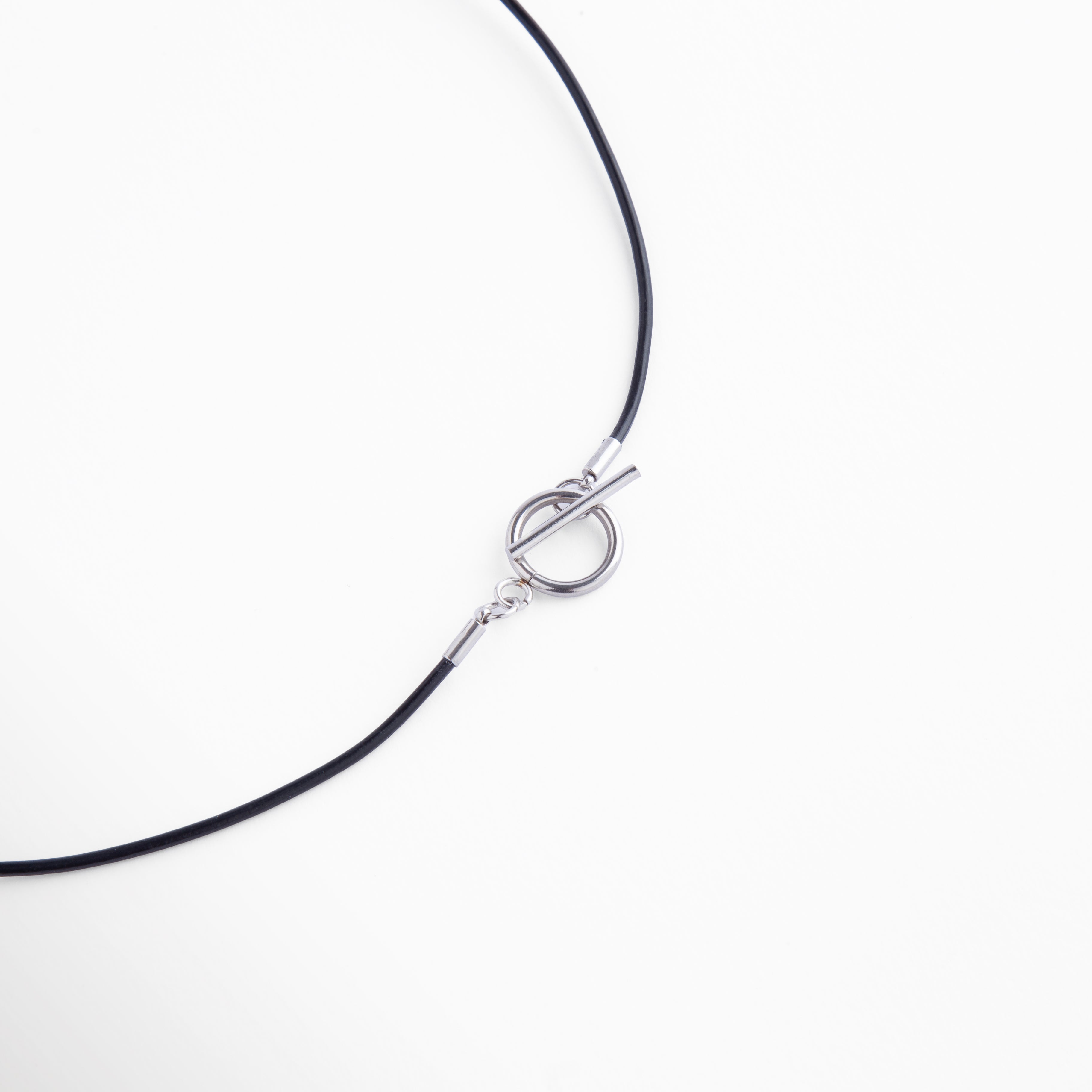 Vista detallada del broche metálico tipo T-bar en tono plateado, un toque moderno y funcional que completa el diseño del collar con un acabado refinado.