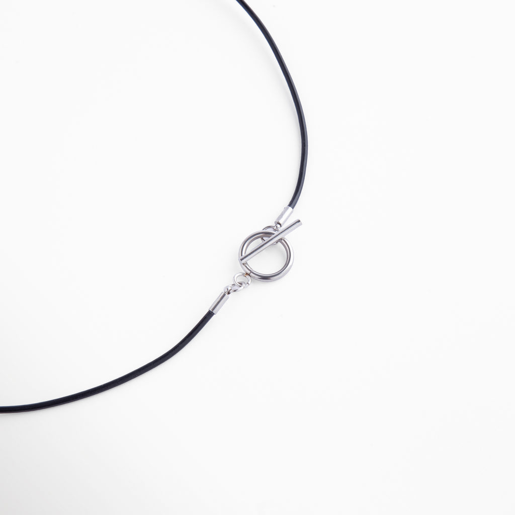 Detalle del broche tipo barra en tono dorado con diseño circular, práctico y elegante, que complementa el estilo refinado del collar.