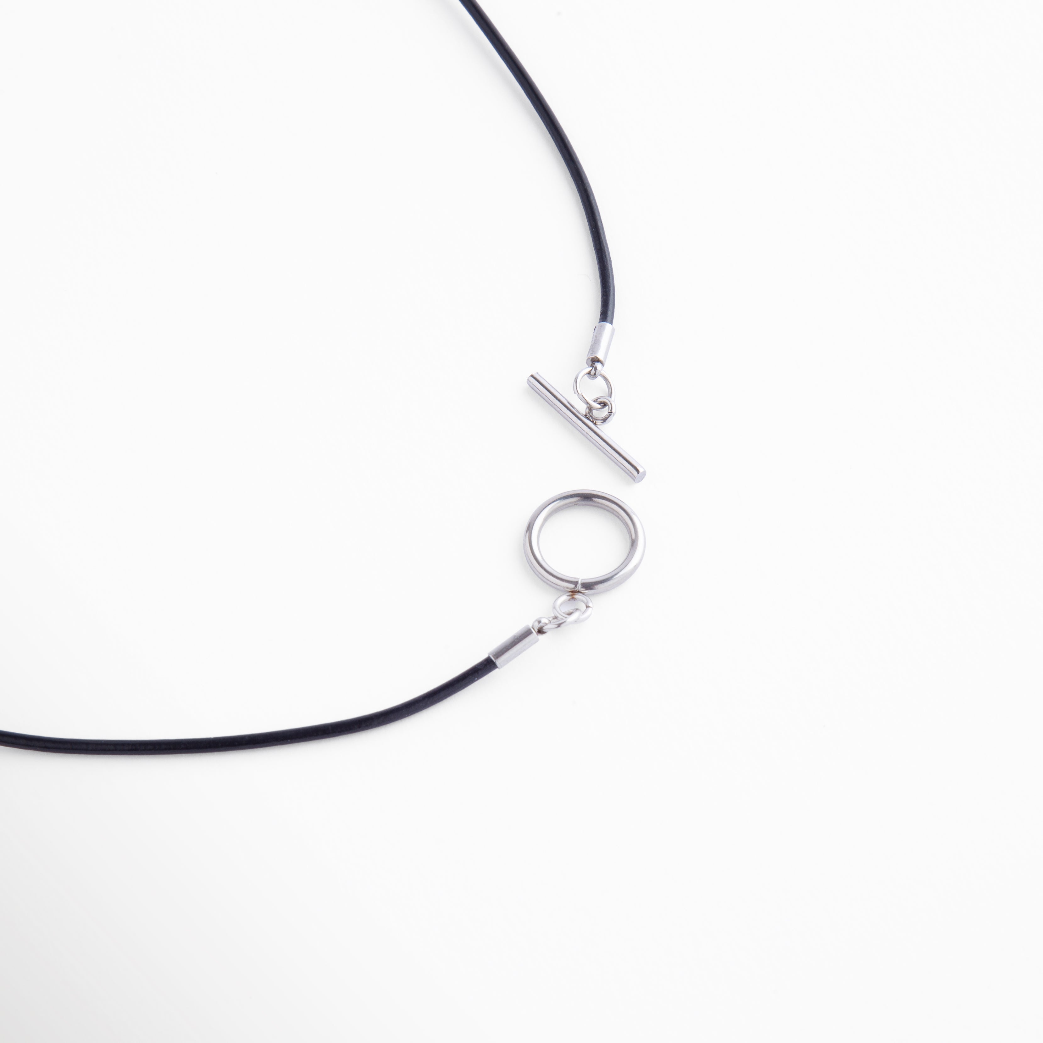 Detalle del cierre tipo barra en acero plateado con diseño circular, fácil de usar y elegante, que complementa el estilo sofisticado del collar.