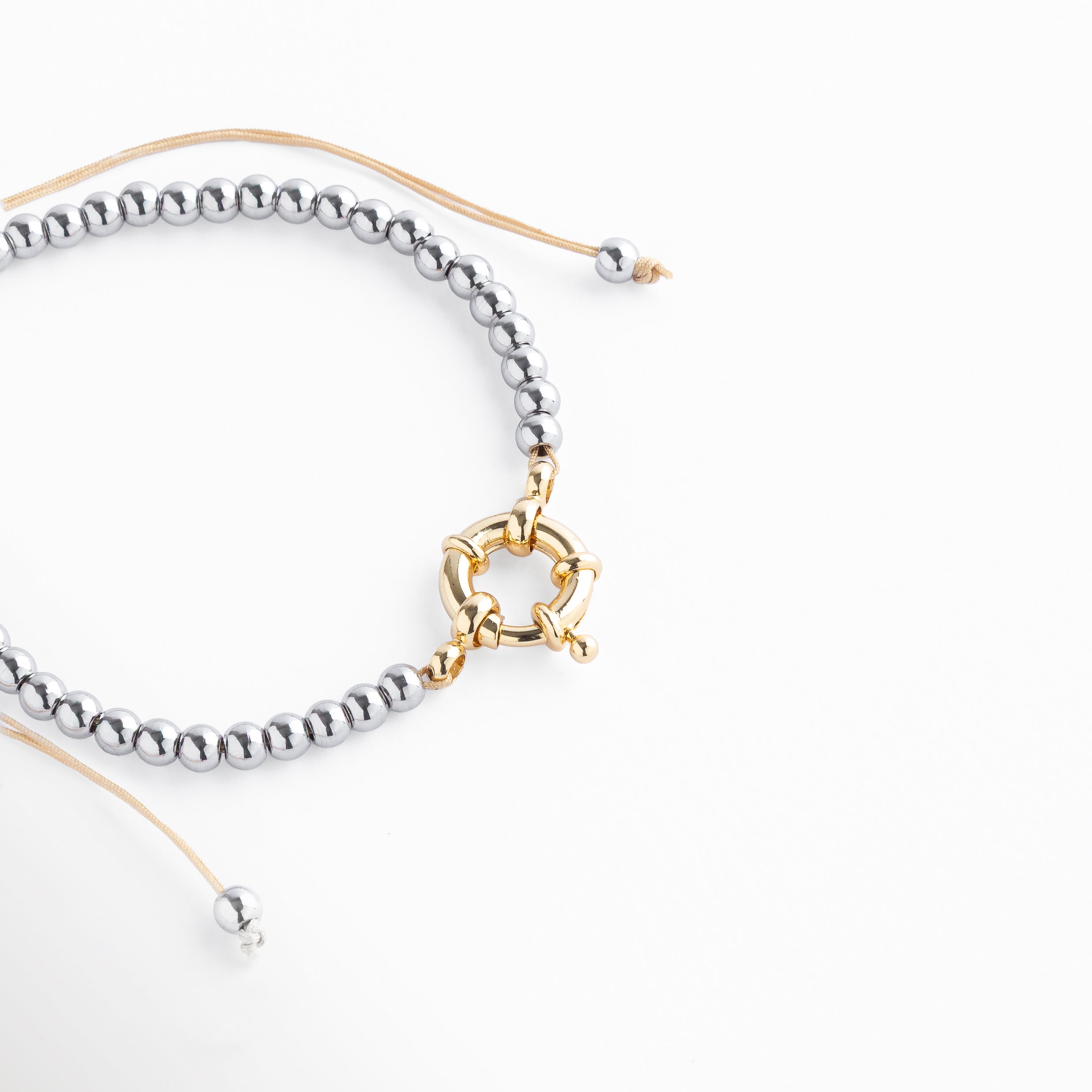 pulsera de acero plateado con cuentas esféricas, diseño moderno con cierre circular dorado, pulsera ajustable elegante, pulsera minimalista de acero inoxidable, accesorio versátil para uso diario