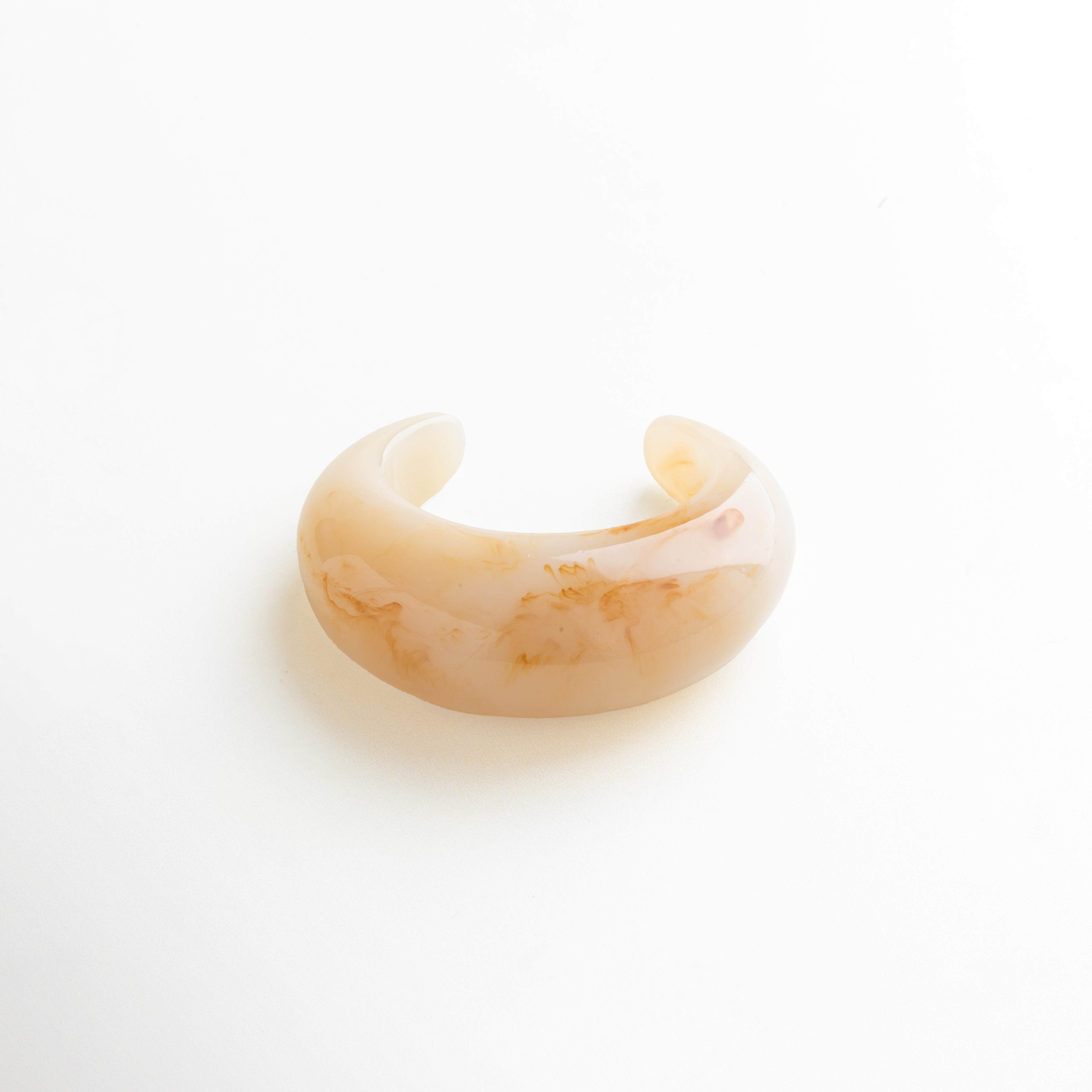 Pulsera ancha de resina en tono beige con vetas orgánicas, diseño bold y sofisticado, accesorio moderno y versátil para un estilo contemporáneo.