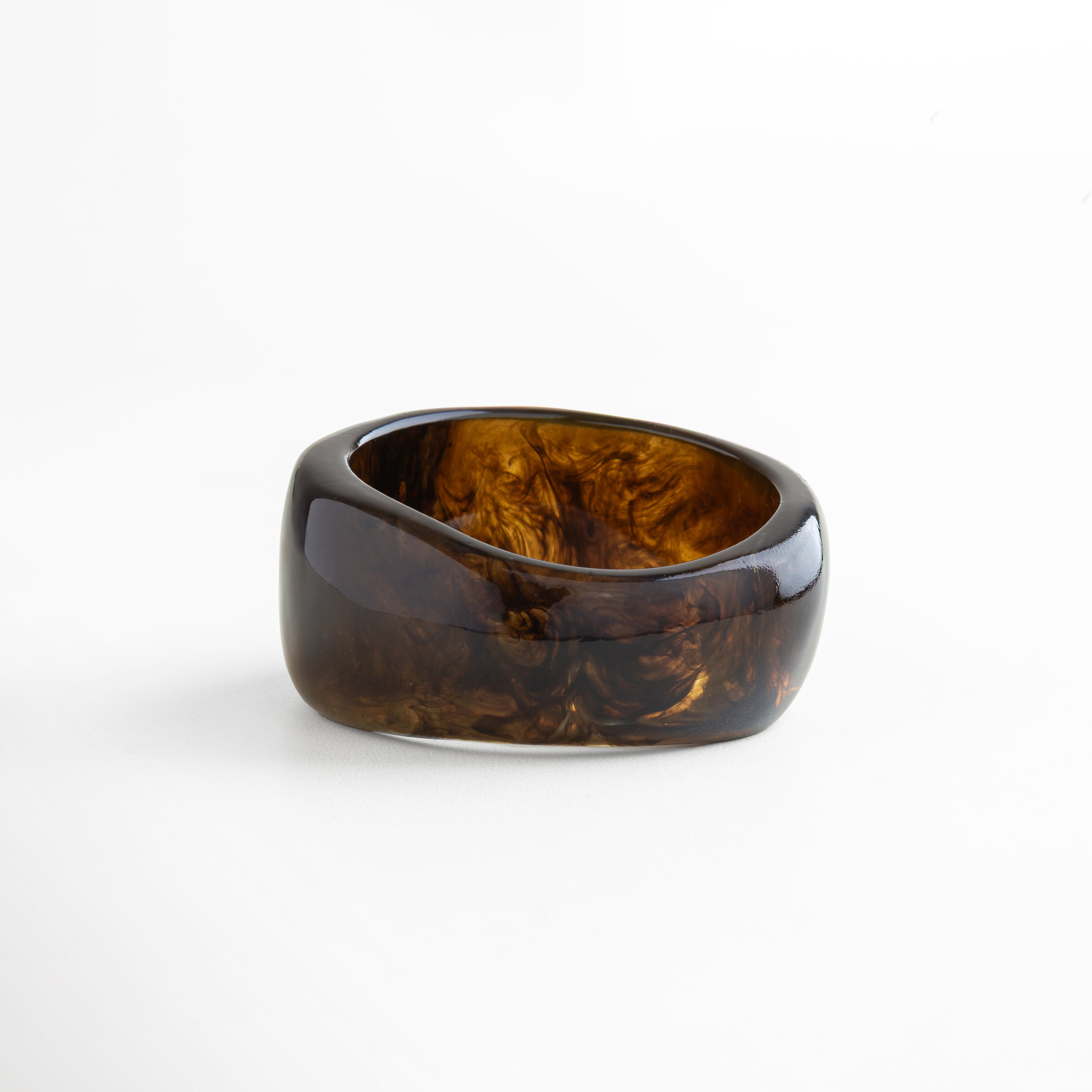 Pulsera de resina oscura marmoleada con acabado pulido, diseño contemporáneo y versátil para quienes buscan un accesorio statement.