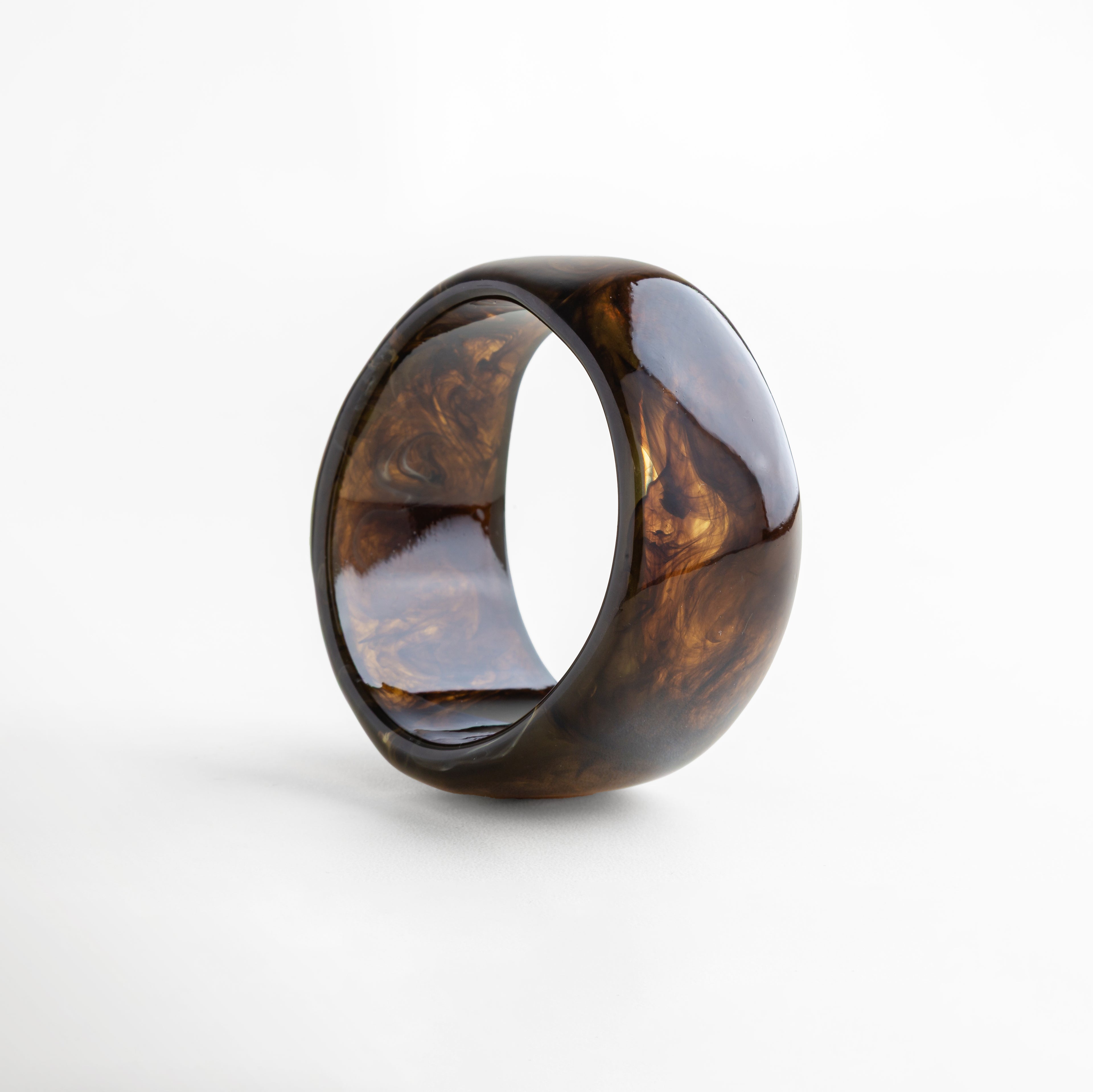 Pulsera bold de resina en tono ámbar brillante con acabado marmoleado, pieza moderna y llamativa que realza cualquier outfit.