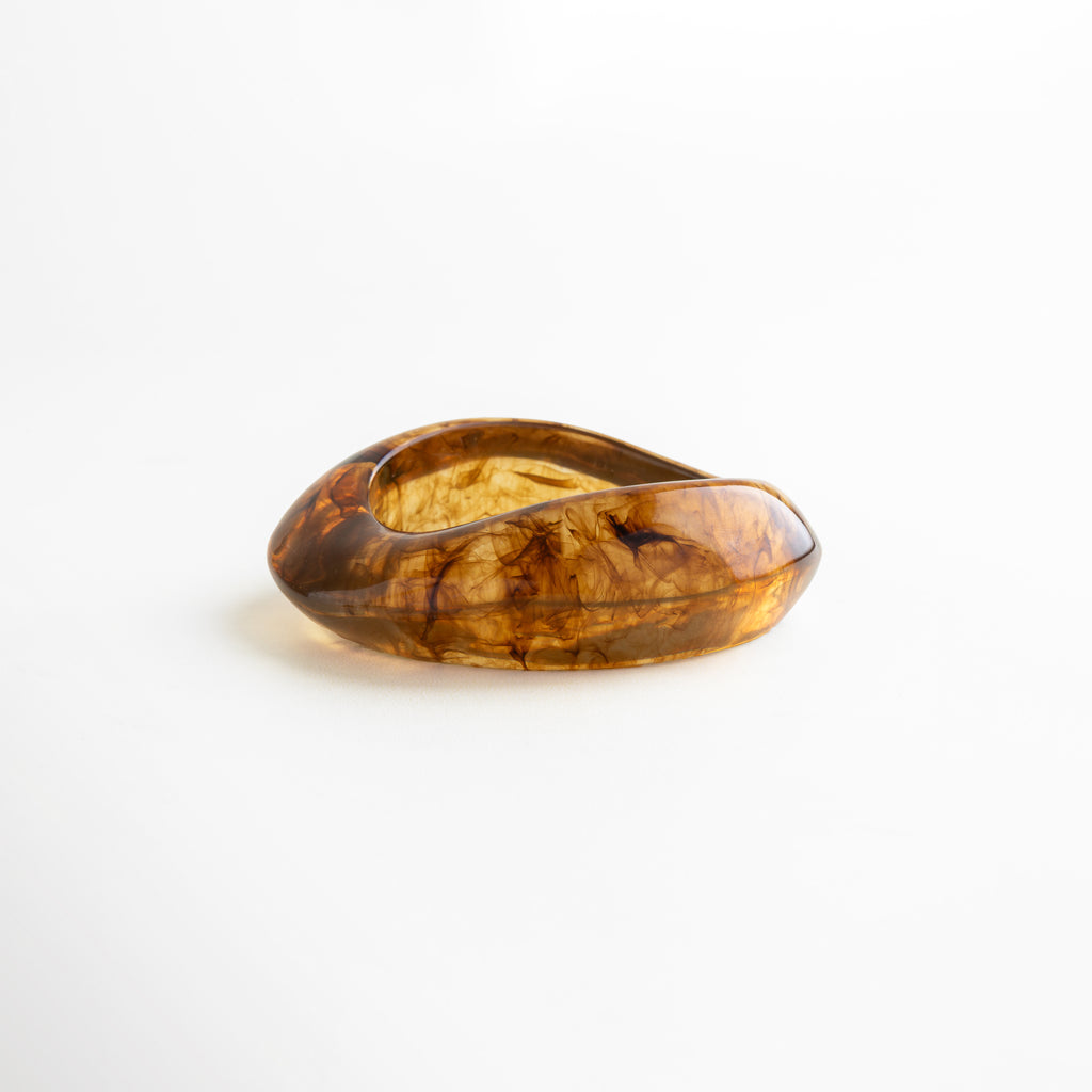 Pulsera de resina marrón ámbar con textura marmoleada, diseño elegante y contemporáneo que transmite carácter y sofisticación.