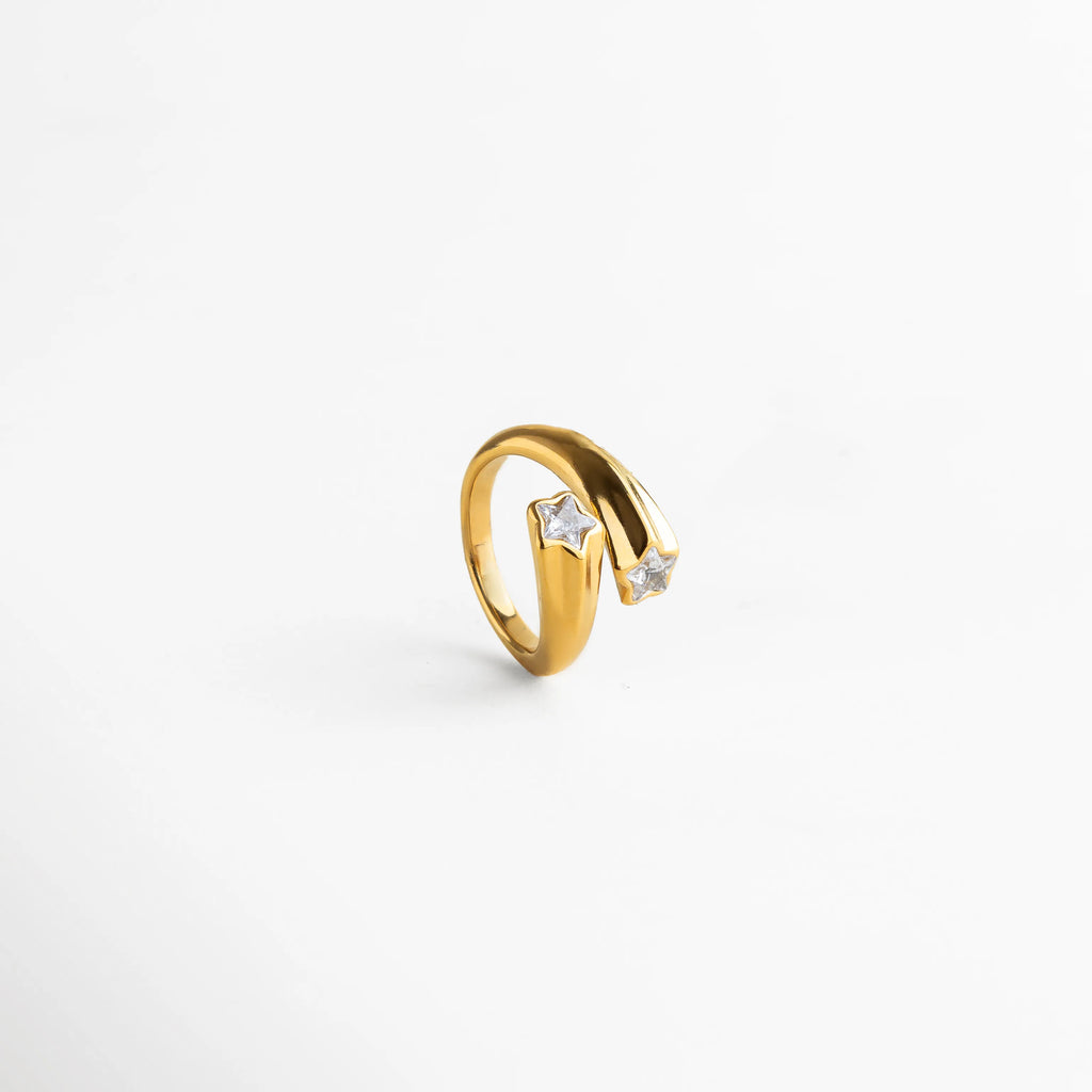 Anillo dorado con dos estrellas brillantes en los extremos, una pieza delicada y elegante inspirada en el cielo nocturno.