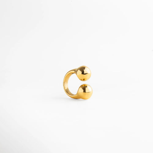 Anillo dorado abierto con diseño de doble esfera pulida, acabado brillante y estilo minimalista moderno.