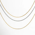 Collar de tres capas en combinación dorada y plateada, con cadenas tipo serpiente y trenza, ideal para un look moderno y elegante.