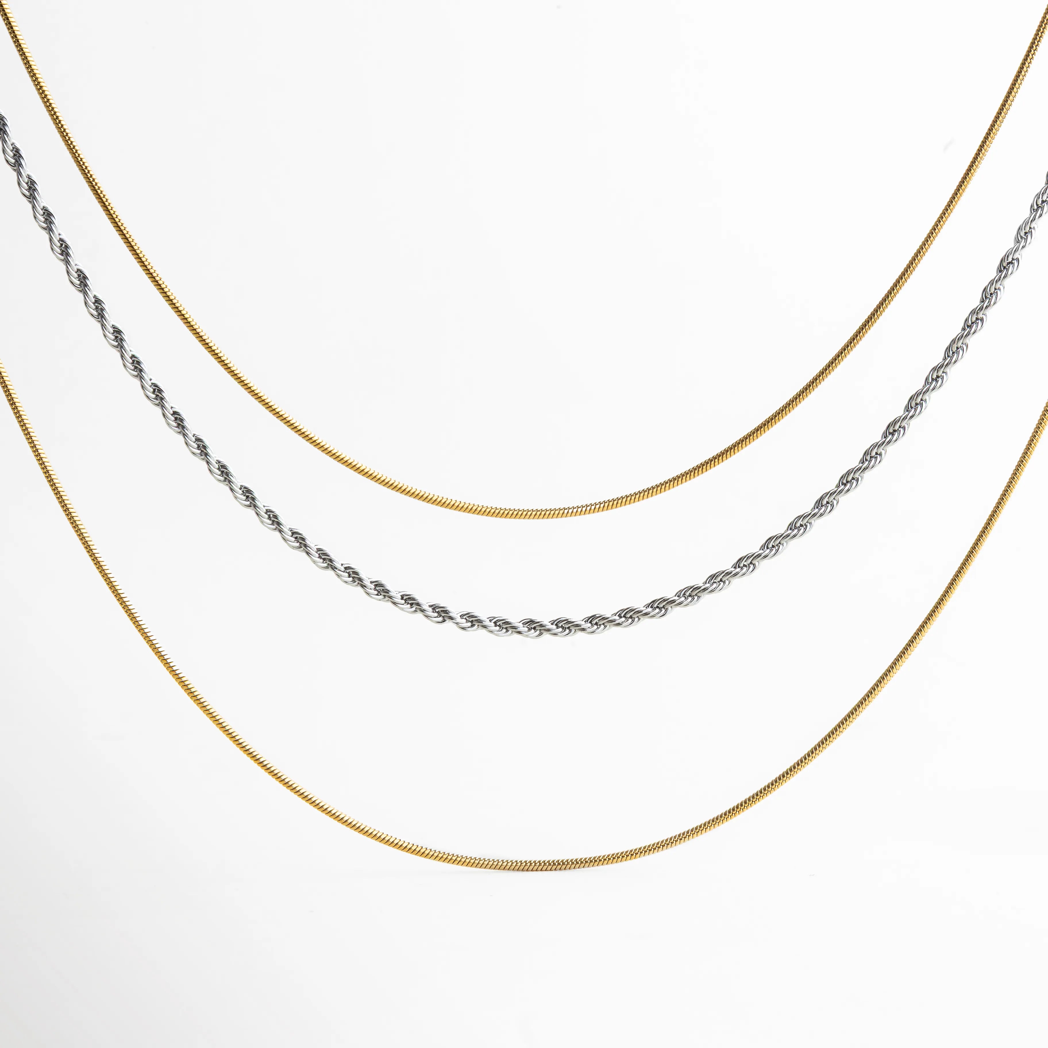 Collar de tres capas en combinación dorada y plateada, con cadenas tipo serpiente y trenza, ideal para un look moderno y elegante.