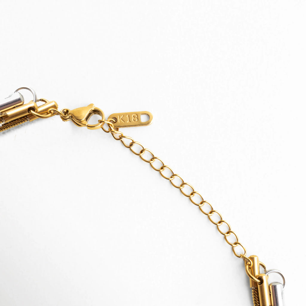 Cierre ajustable dorado con extensión de eslabones finos y grabado metálico, acabado pulido que asegura comodidad y estilo.