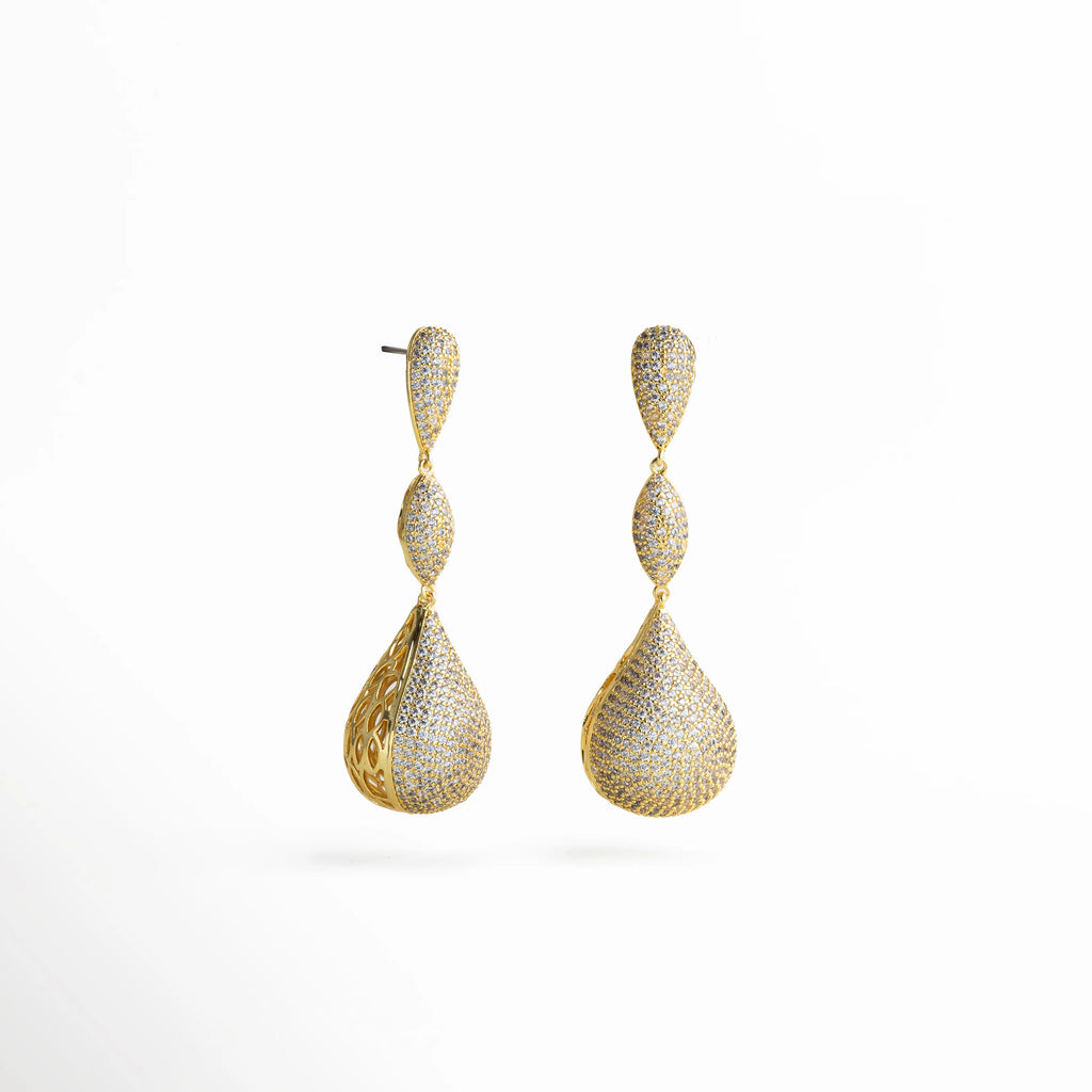 Aretes dorados con forma de lágrima facetada, adornados con zirconias brillantes y estructura articulada que aporta movimiento y elegancia.