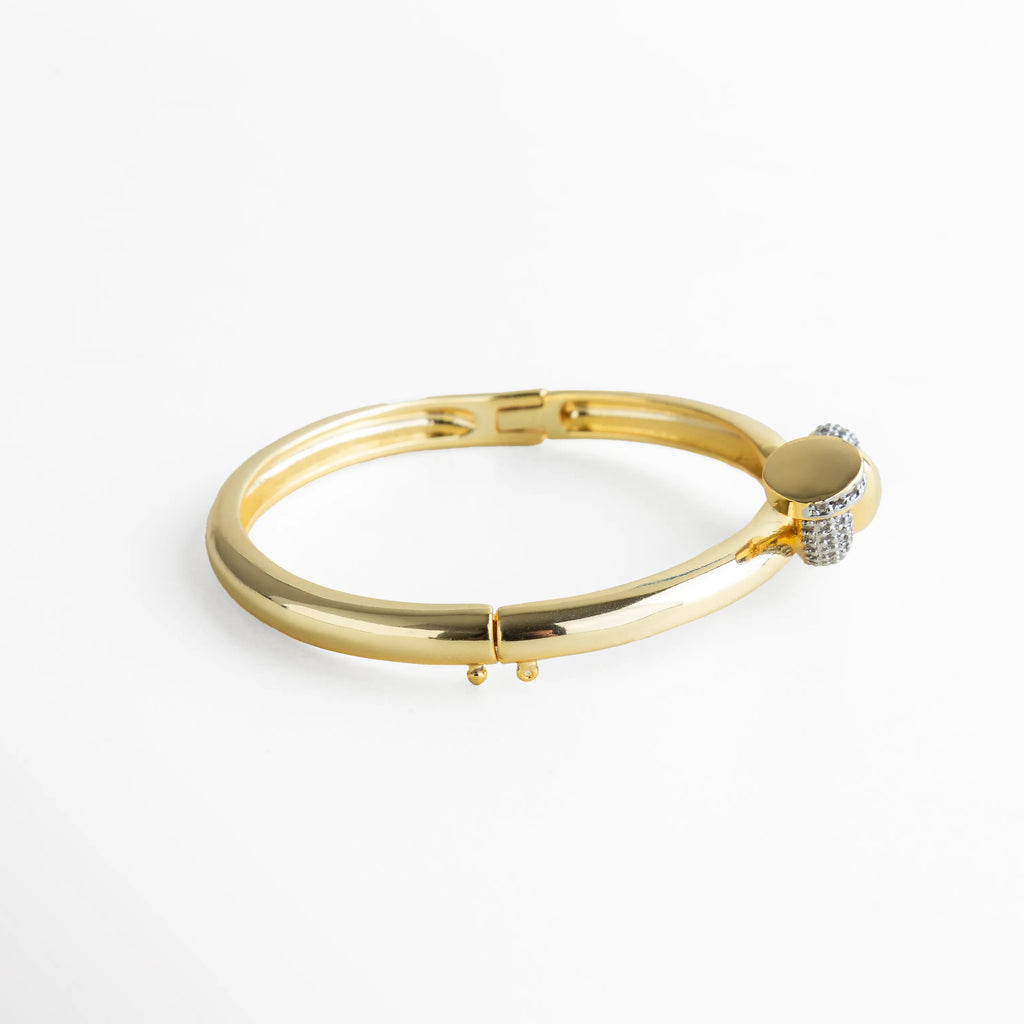 Pulsera dorada con cierre oculto, presentada en vista lateral para mostrar su acabado pulido y la continuidad impecable del diseño. La superficie reflectante realza su calidad y el brillo delicado de las zirconias, aportando una sensación de elegancia atemporal.