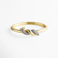 Pulsera dorada tipo brazalete con detalle de nudo central adornado con zirconias transparentes incrustadas. La mezcla entre el brillo del metal y el resplandor de las piedras crea un efecto elegante y sofisticado, ideal para elevar cualquier look con un toque moderno y refinado.