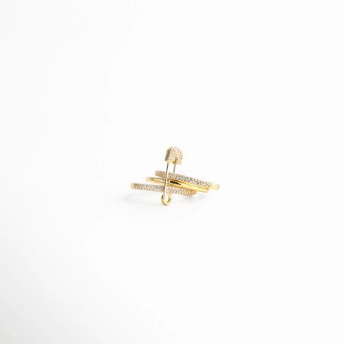 Vista lateral del anillo dorado con diseño estructural y líneas superpuestas que crean un efecto contemporáneo y elegante.