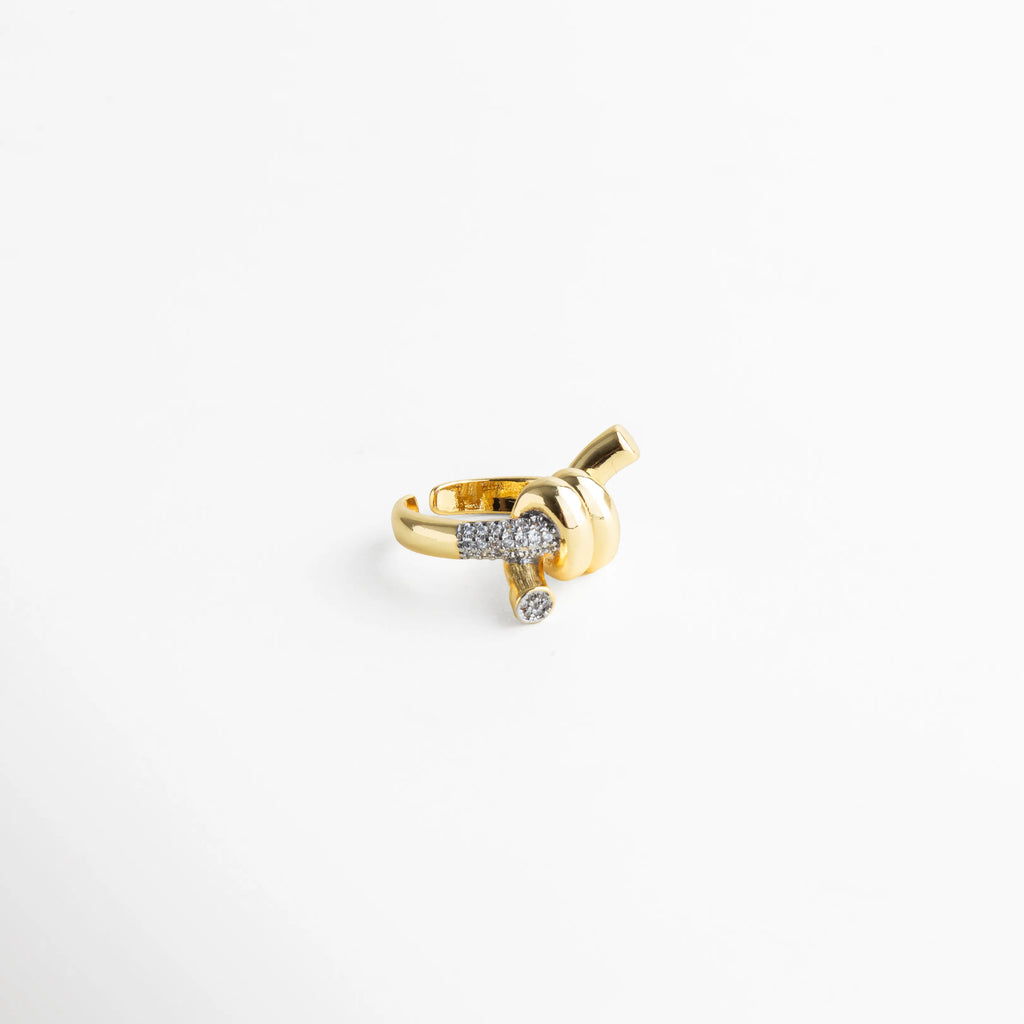 Anillo con estructura cruzada en baño dorado y detalles pavé que reflejan la luz.