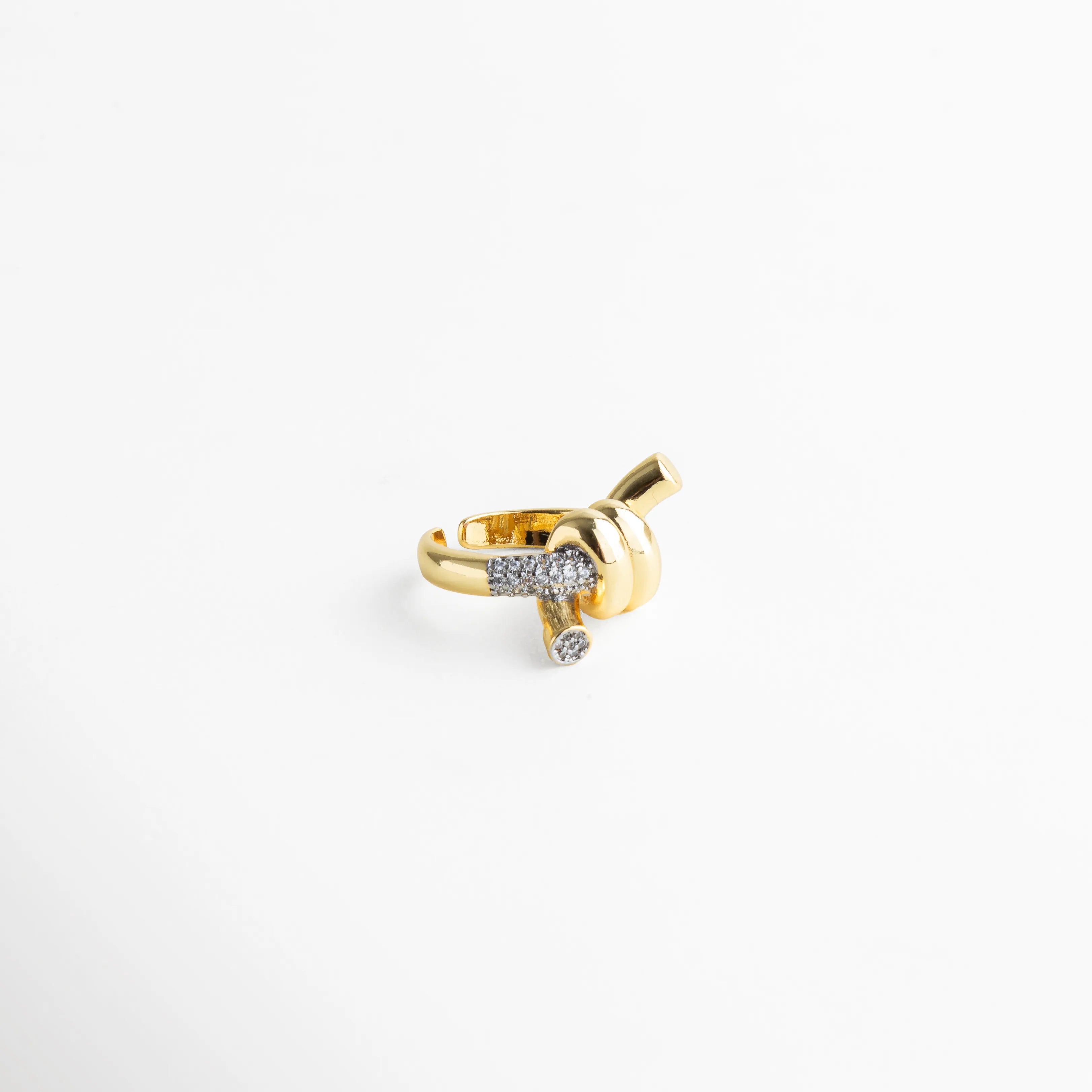 Anillo con estructura cruzada en baño dorado y detalles pavé que reflejan la luz.