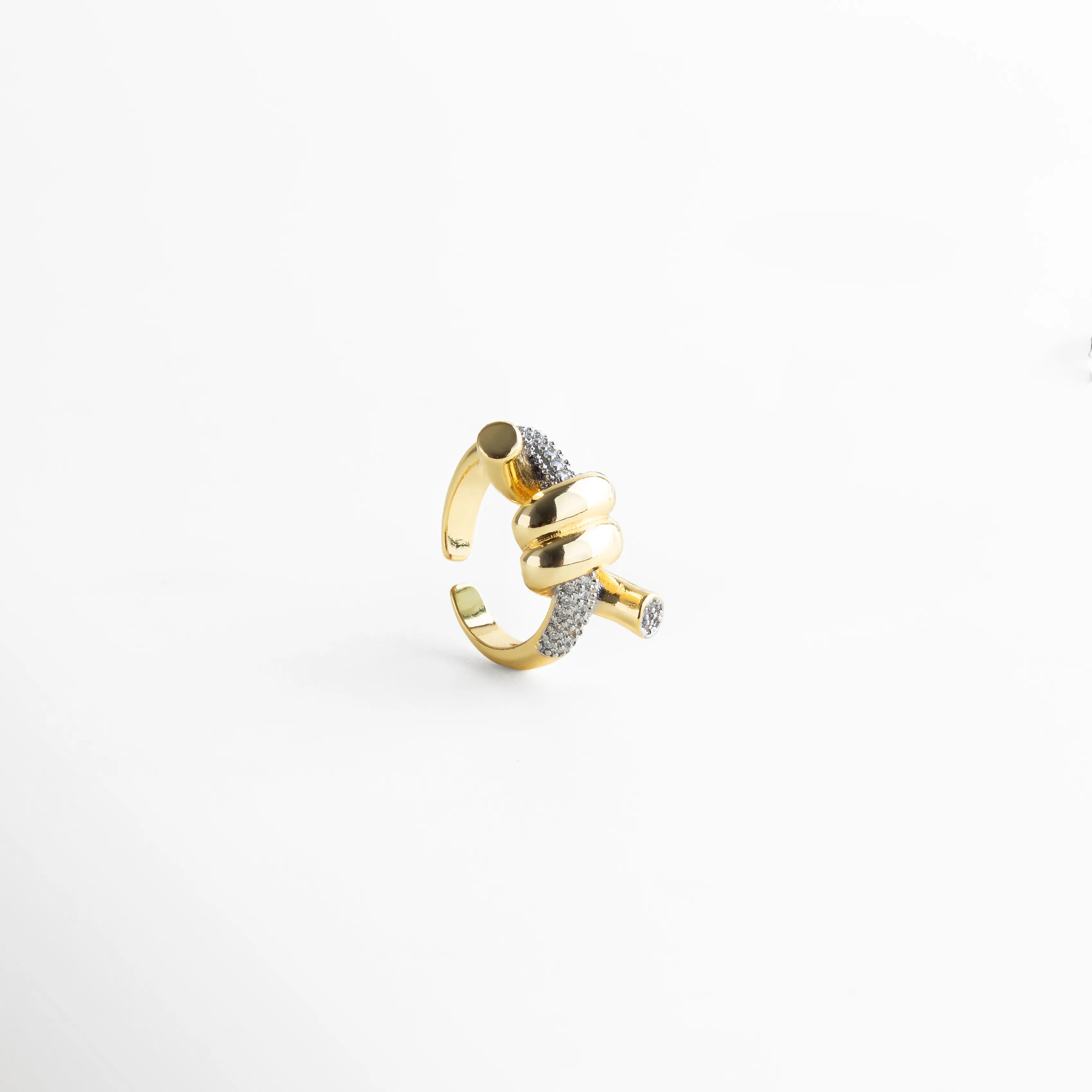 Anillo dorado con nudo central y bordes brillantes, una joya moderna y llamativa.