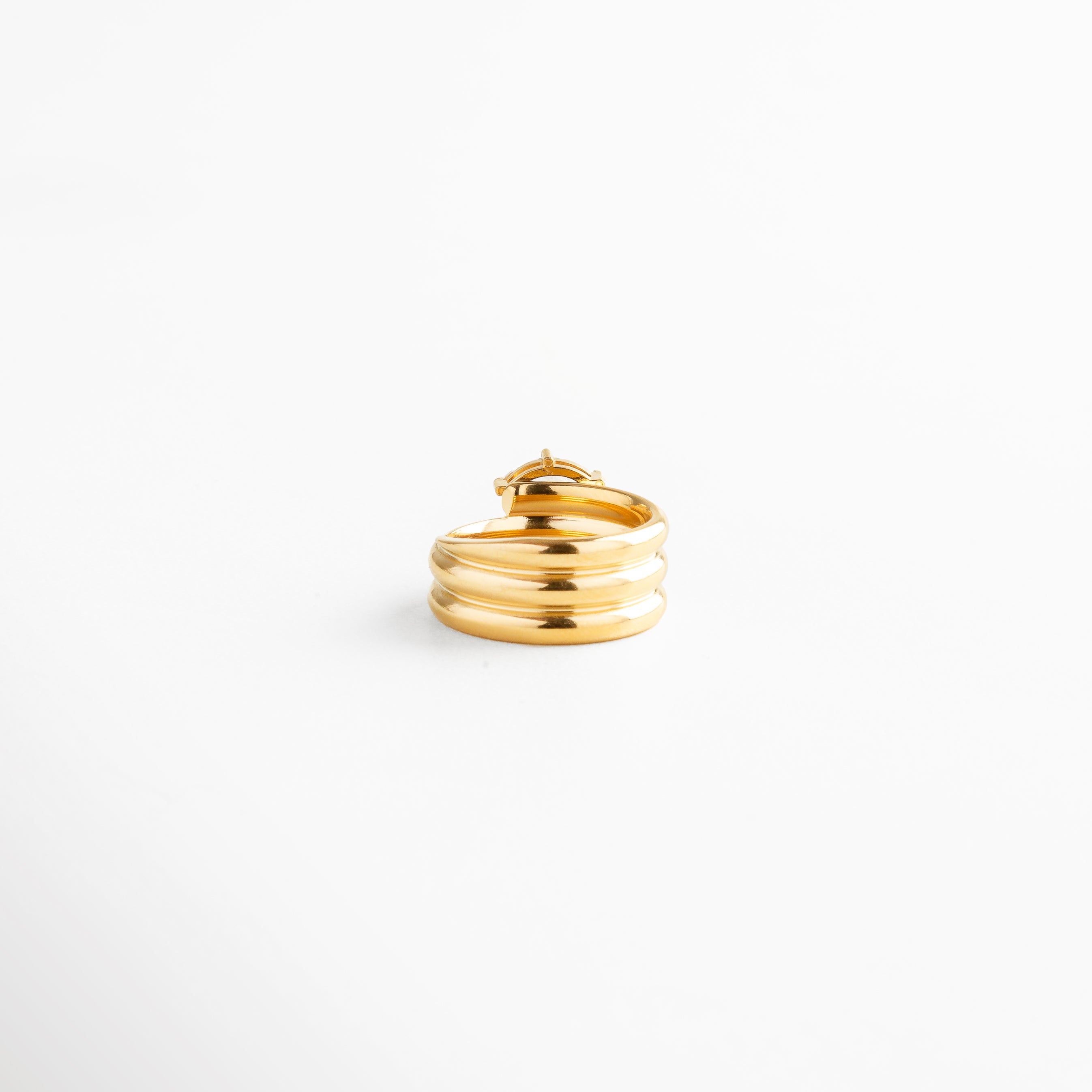 Vista lateral de anillo triple aro dorado con zirconia marquise engastada en oro 18K