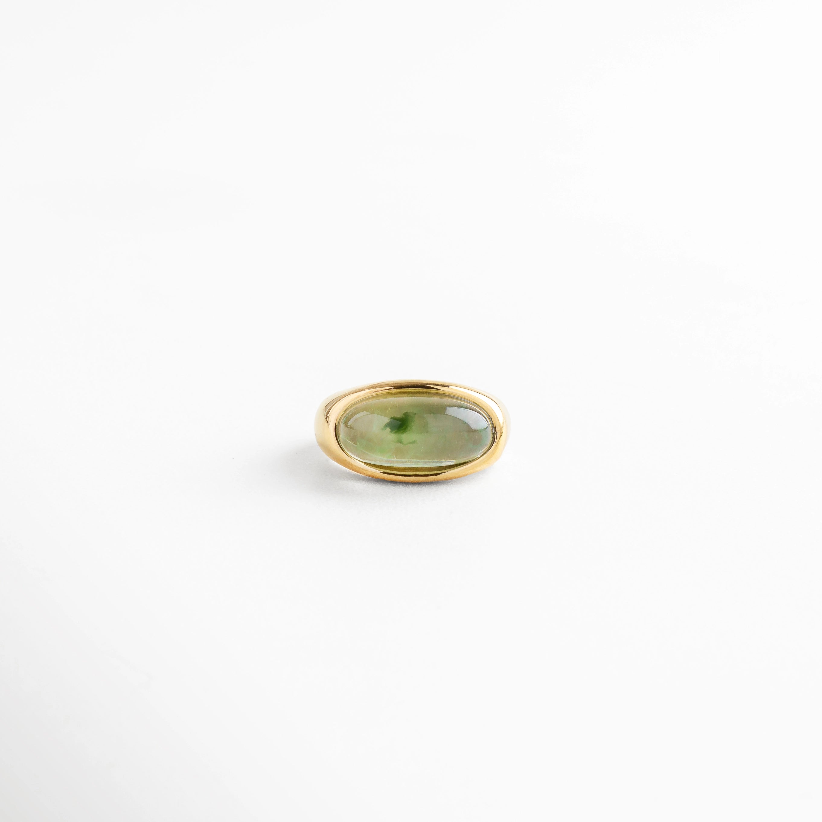 Anillo dorado de acero inoxidable con piedra verde de resina ovalada, diseño elegante y atemporal con acabado brillante.