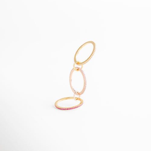 Anillo de tres aros enlazados con incrustaciones de zirconias rosas, detalle en plata ley 925 con recubrimiento en oro 18K.