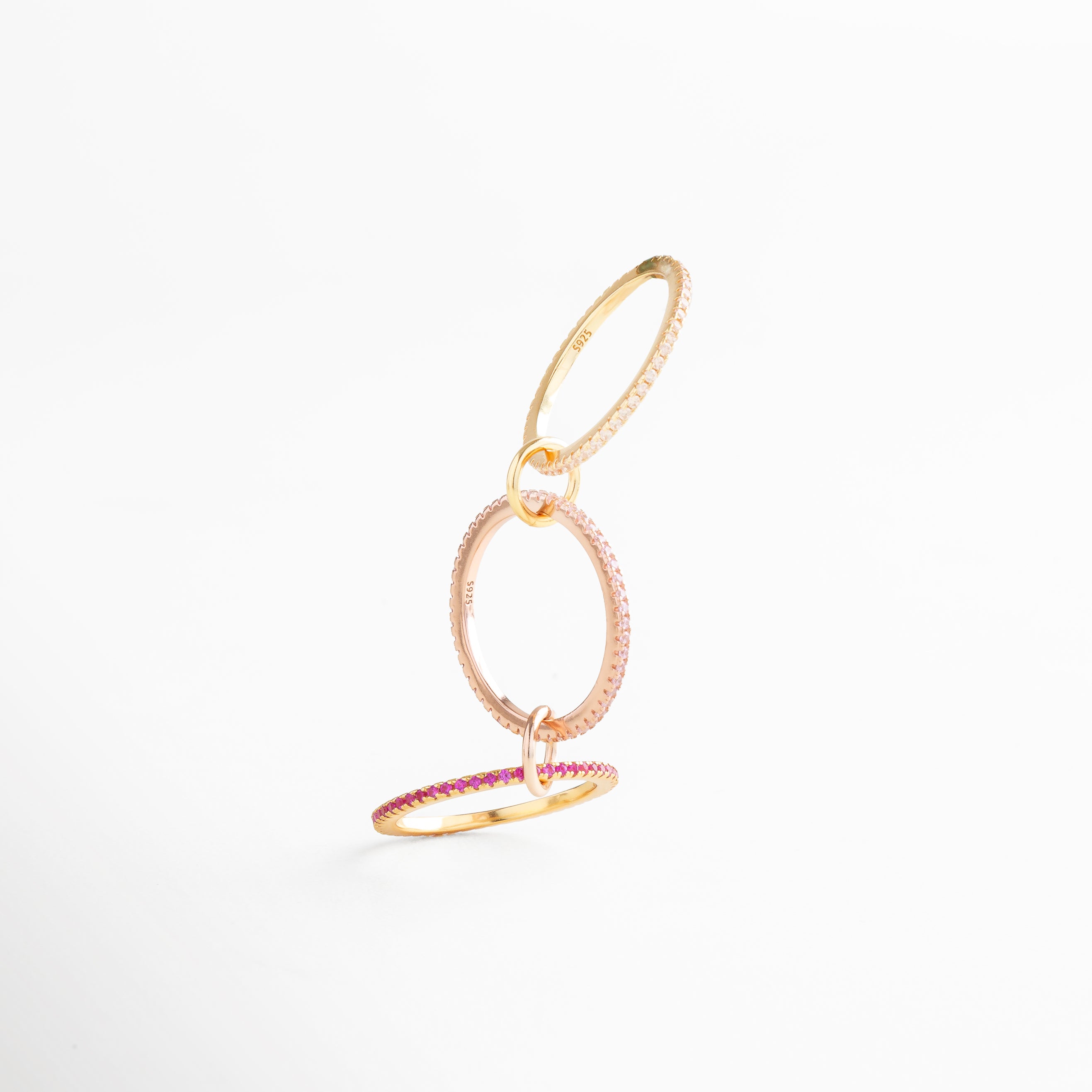 Anillo de diseño contemporáneo en plata 925 con baño de oro 18K, aros entrelazados con zirconias rosas brillantes.