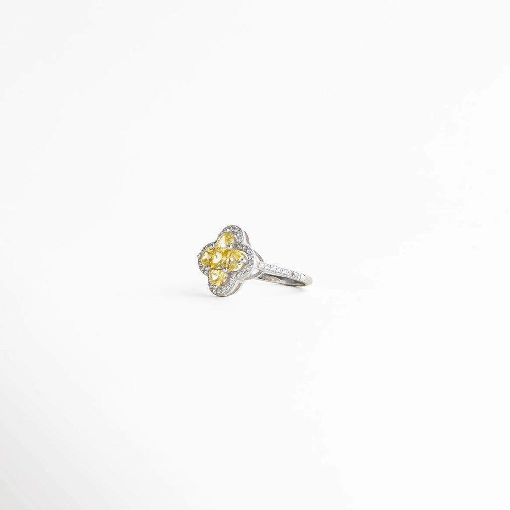 Vista lateral del anillo elegante con estructura delicada y diseño floral que resalta el brillo y la forma del centro.