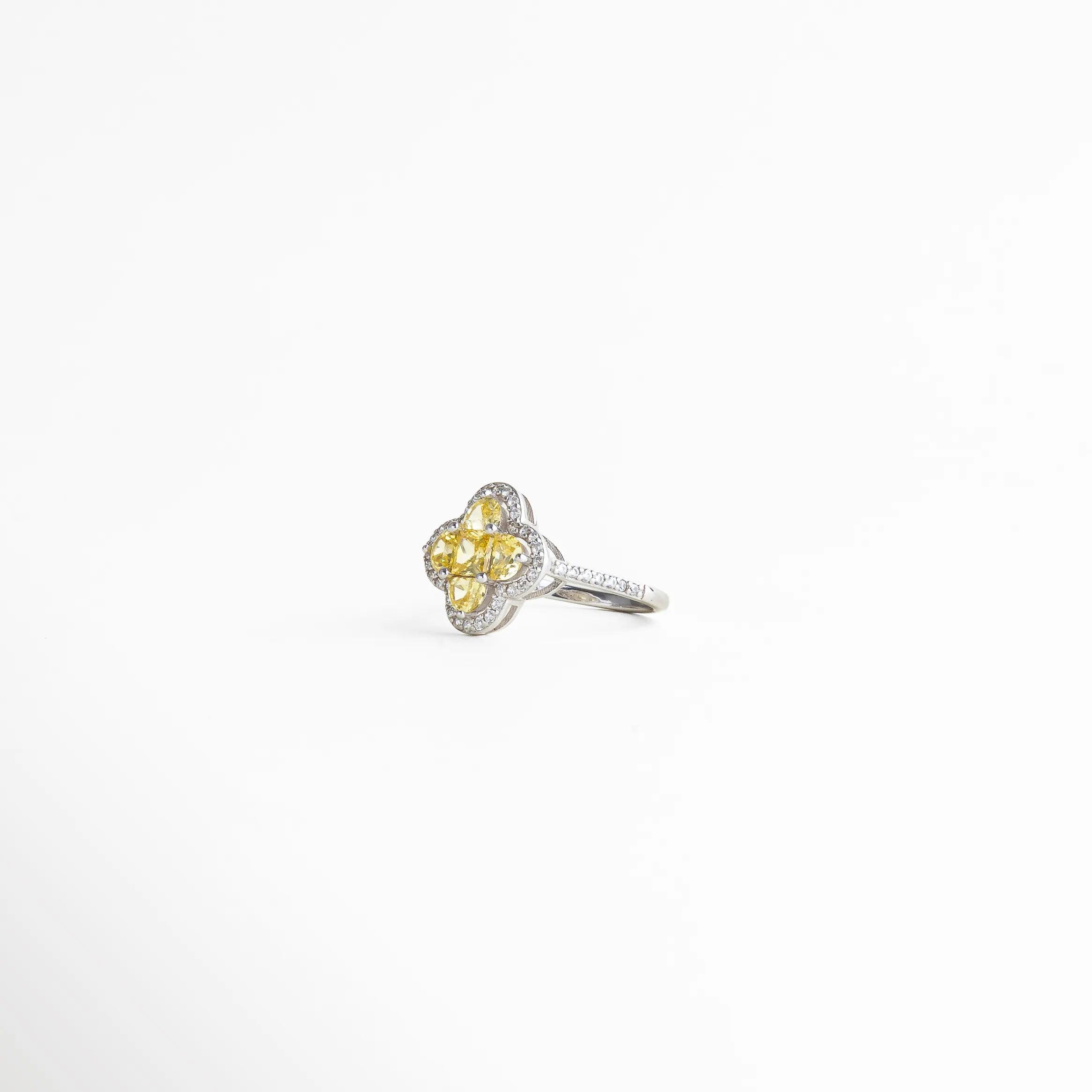 Vista lateral del anillo elegante con estructura delicada y diseño floral que resalta el brillo y la forma del centro.