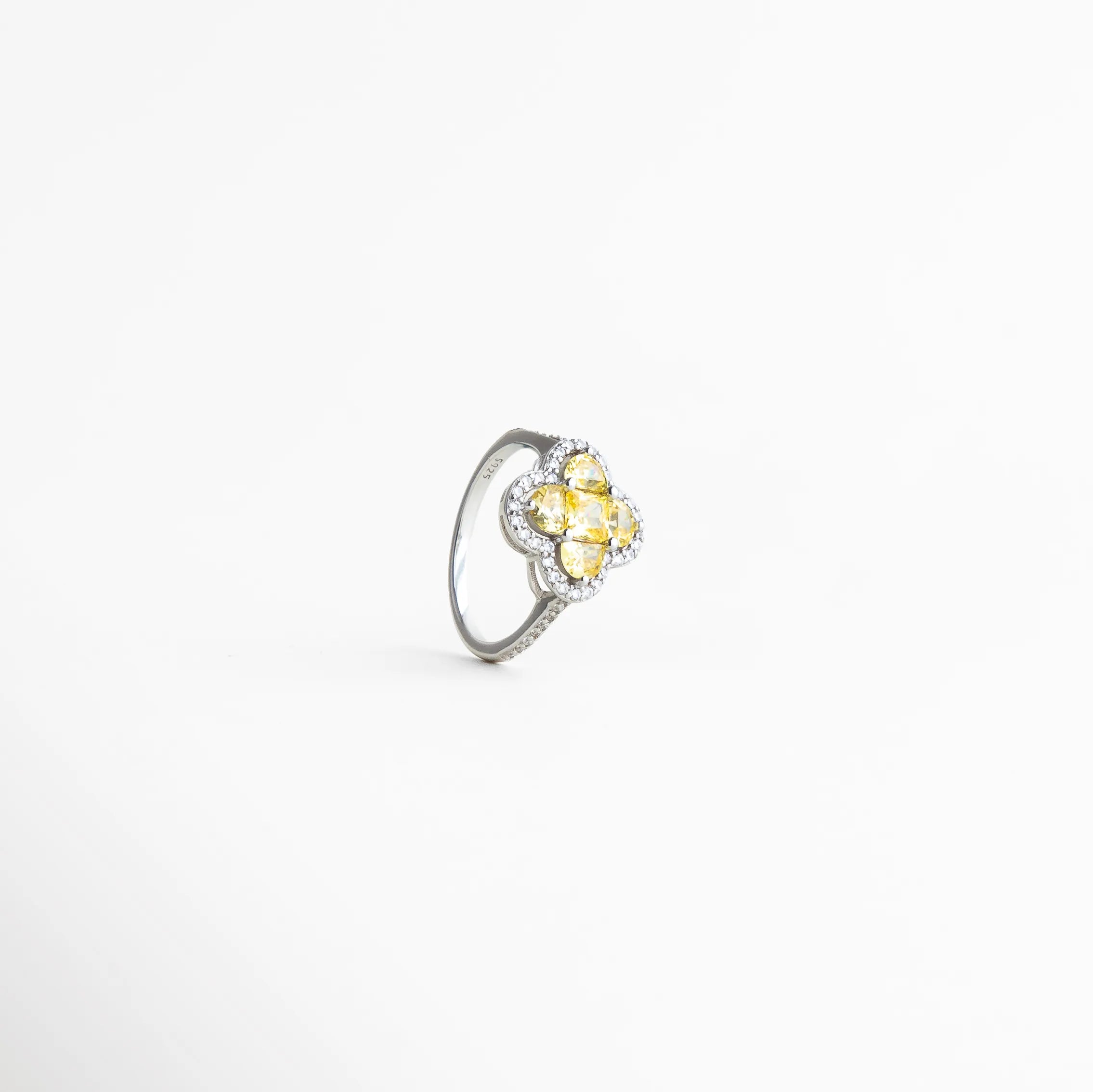 Vista en ángulo del anillo femenino con diseño tipo flor, combinación de tonos dorado y plateado con acabado luminoso.