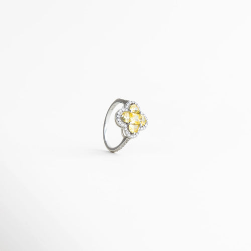 Vista en ángulo del anillo femenino con diseño tipo flor, combinación de tonos dorado y plateado con acabado luminoso.