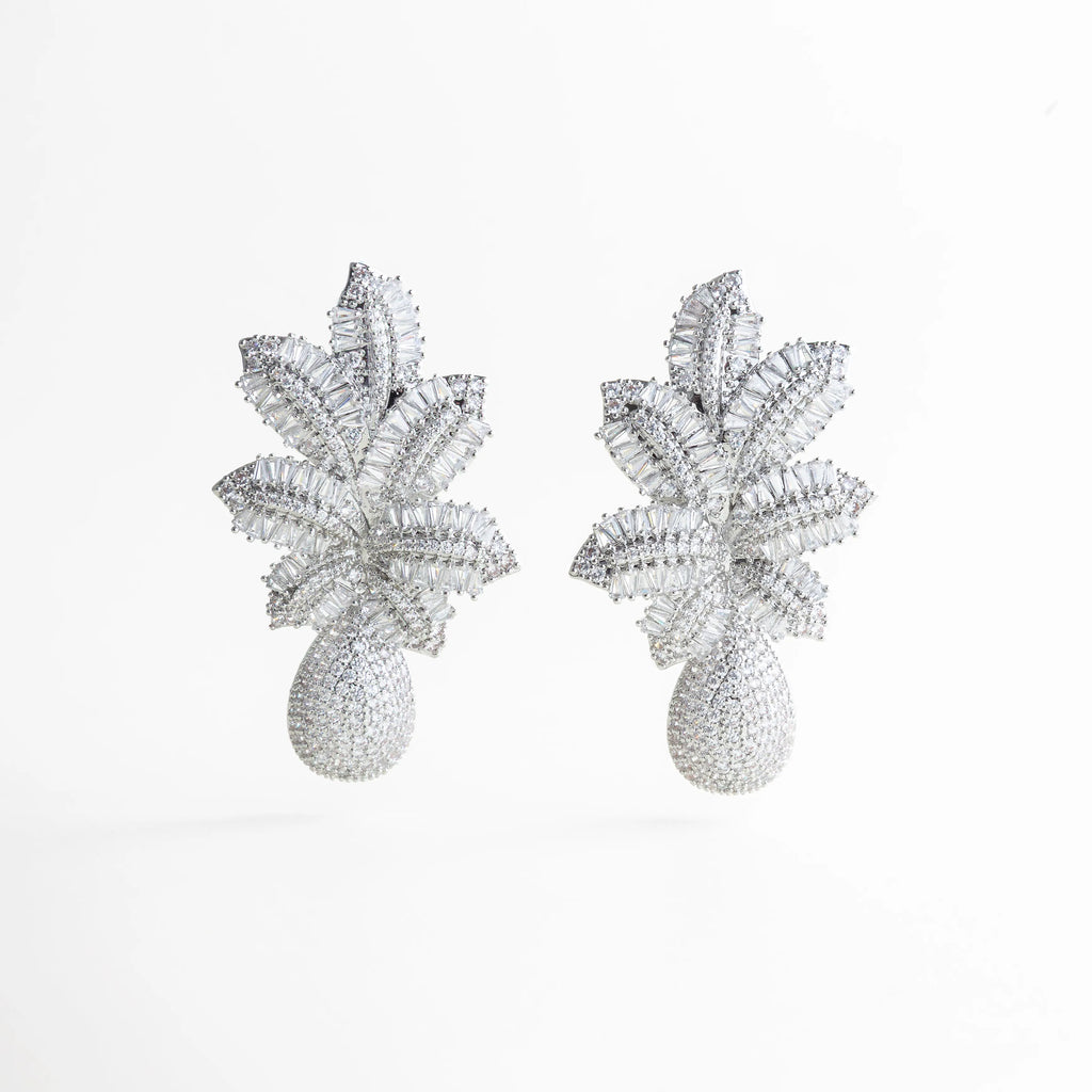 aretes plateados statement de diseño floral volumétrico, aretes largos plateados con textura brillante, joyería statement plateada estilo escultórico, aretes elegantes plateados con formas orgánicas, aretes de impacto plateados para eventos especiales, aretes llamativos plateados con volumen estructural