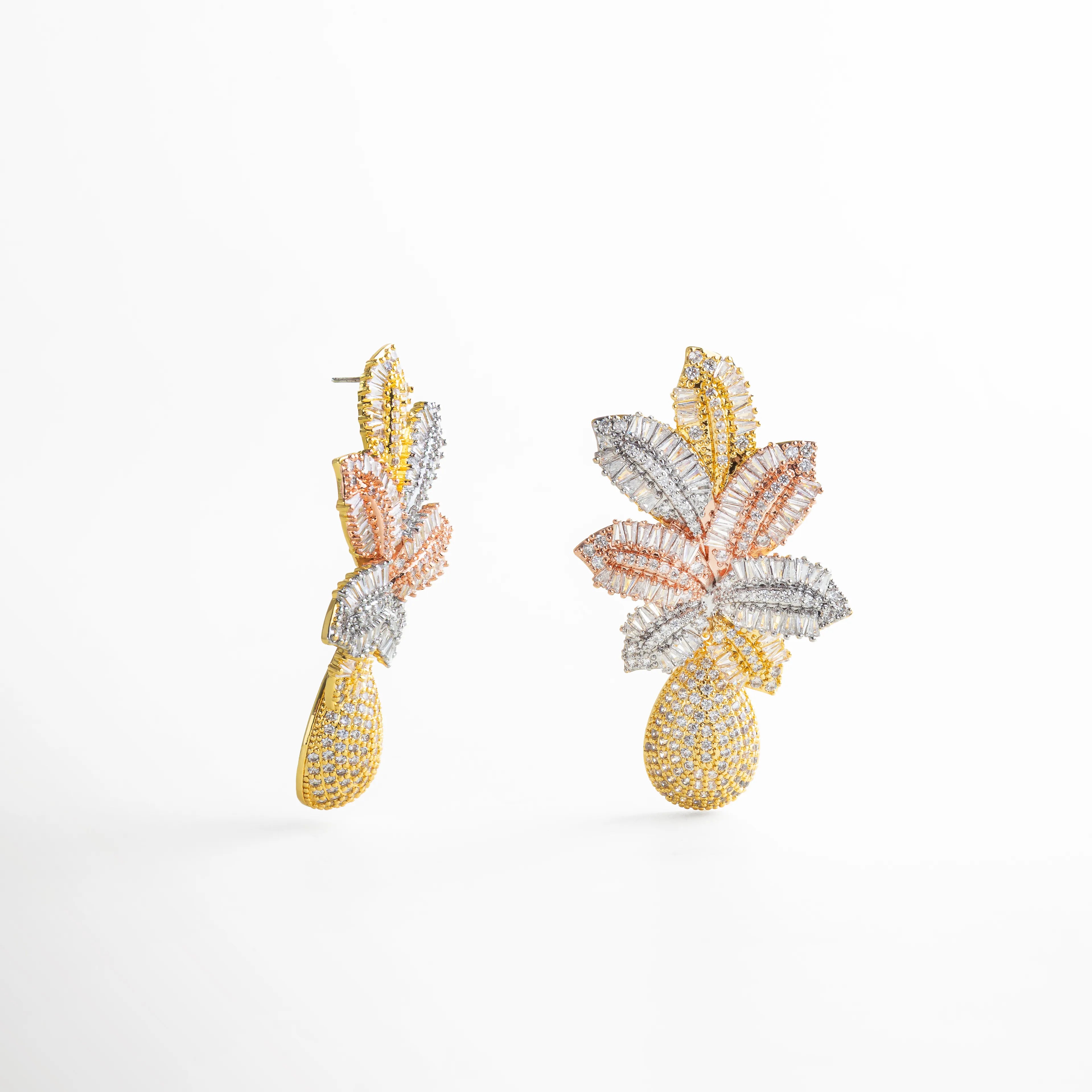 Vista lateral de aretes largos multicolor con brillo intenso y forma de hojas, acabado dorado y gota pavé colgante; fondo blanco.