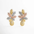 Aretes dorados con cristales multicolor corte baguette formando hojas y gota alargada cubierta de brillo estilo carnaval glam; fondo blanco minimal.