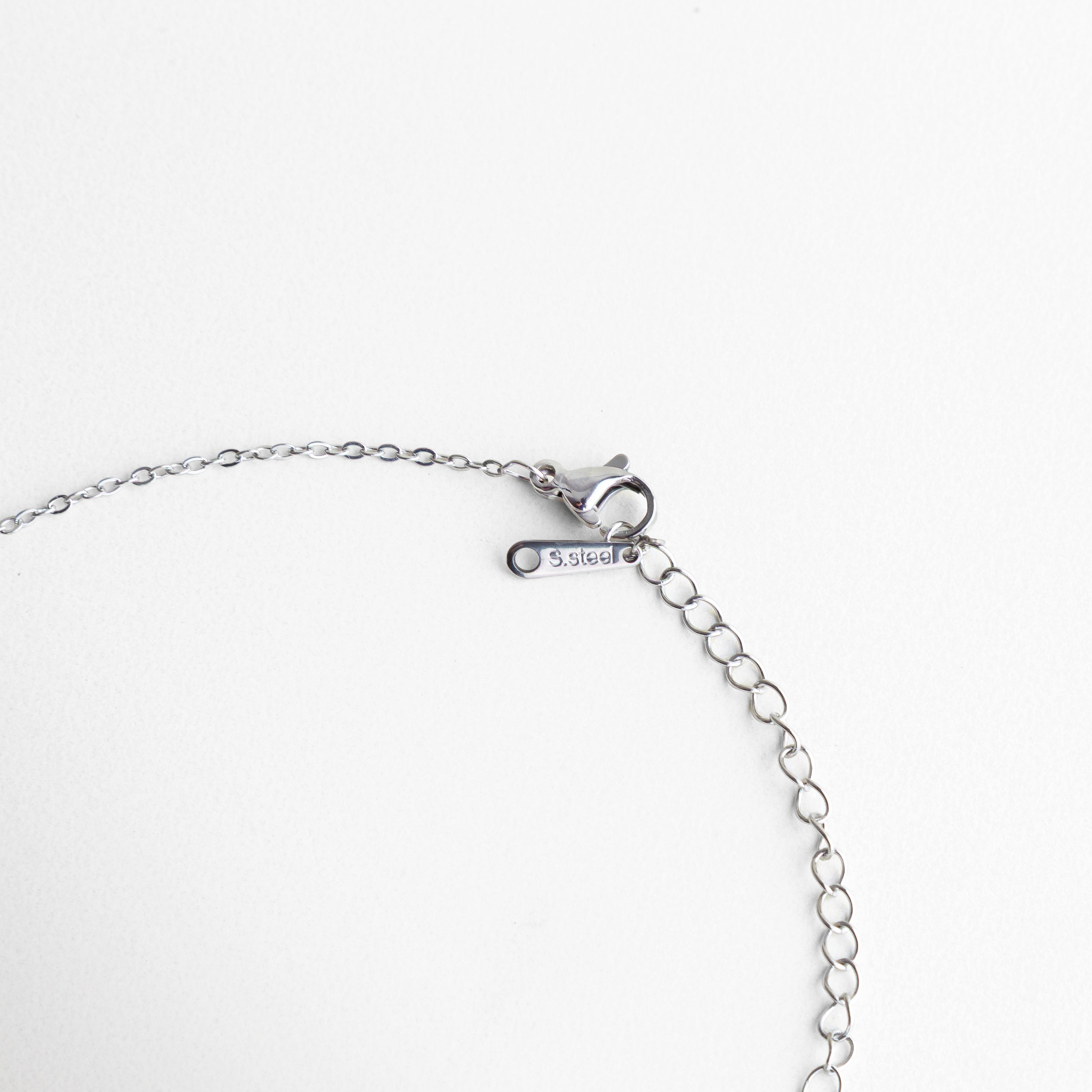 cierre de collar plateado con cadena ajustable, broche tipo langosta en collar femenino, detalle de cadena extensible en collar, sistema de ajuste en collar minimal, broche metálico en collar delicado