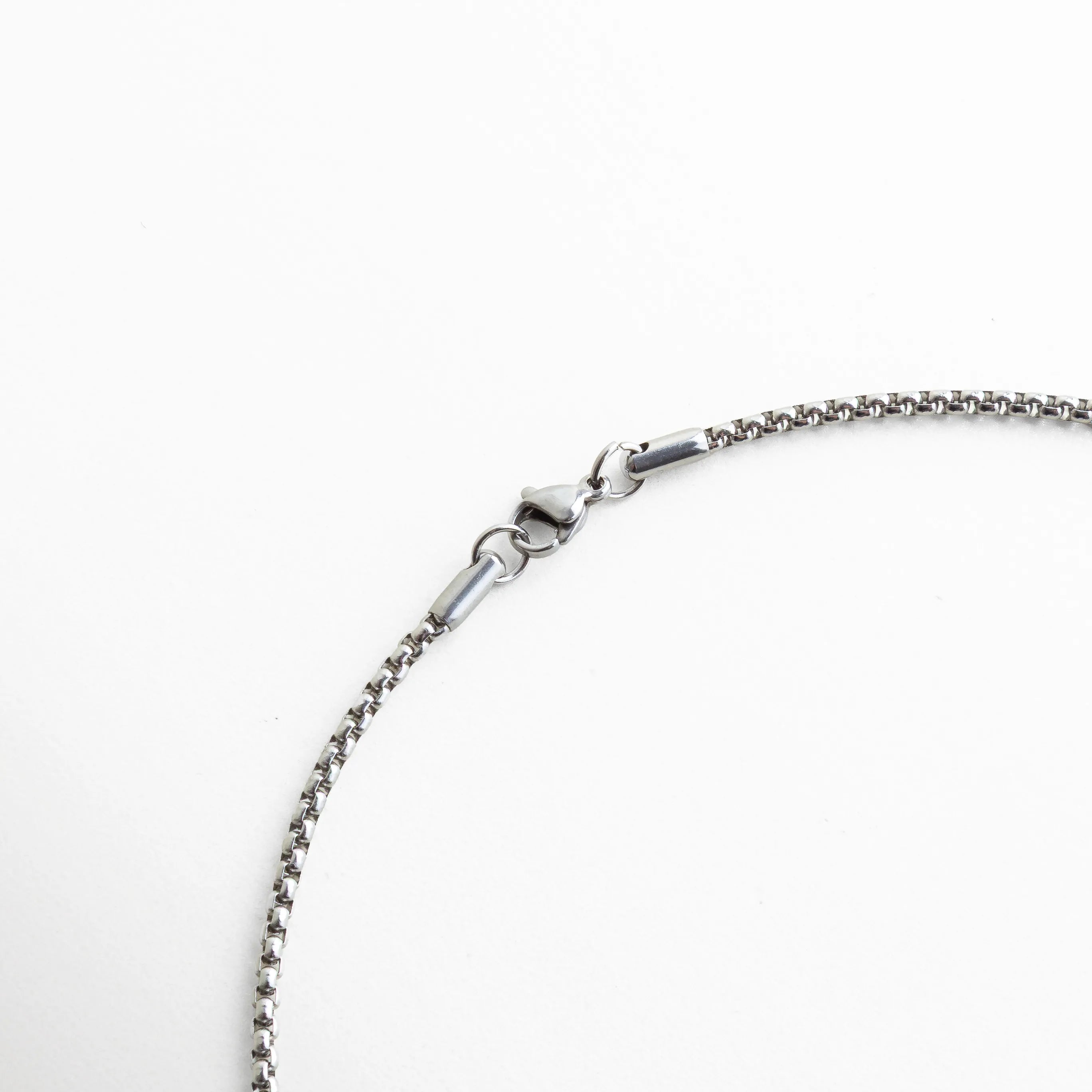 Primer plano del broche del collar, mostrando su estructura de eslabones finos y su cierre tipo mosquetón. La imagen resalta la calidad del acabado y la atención al detalle en cada unión, garantizando durabilidad y comodidad.