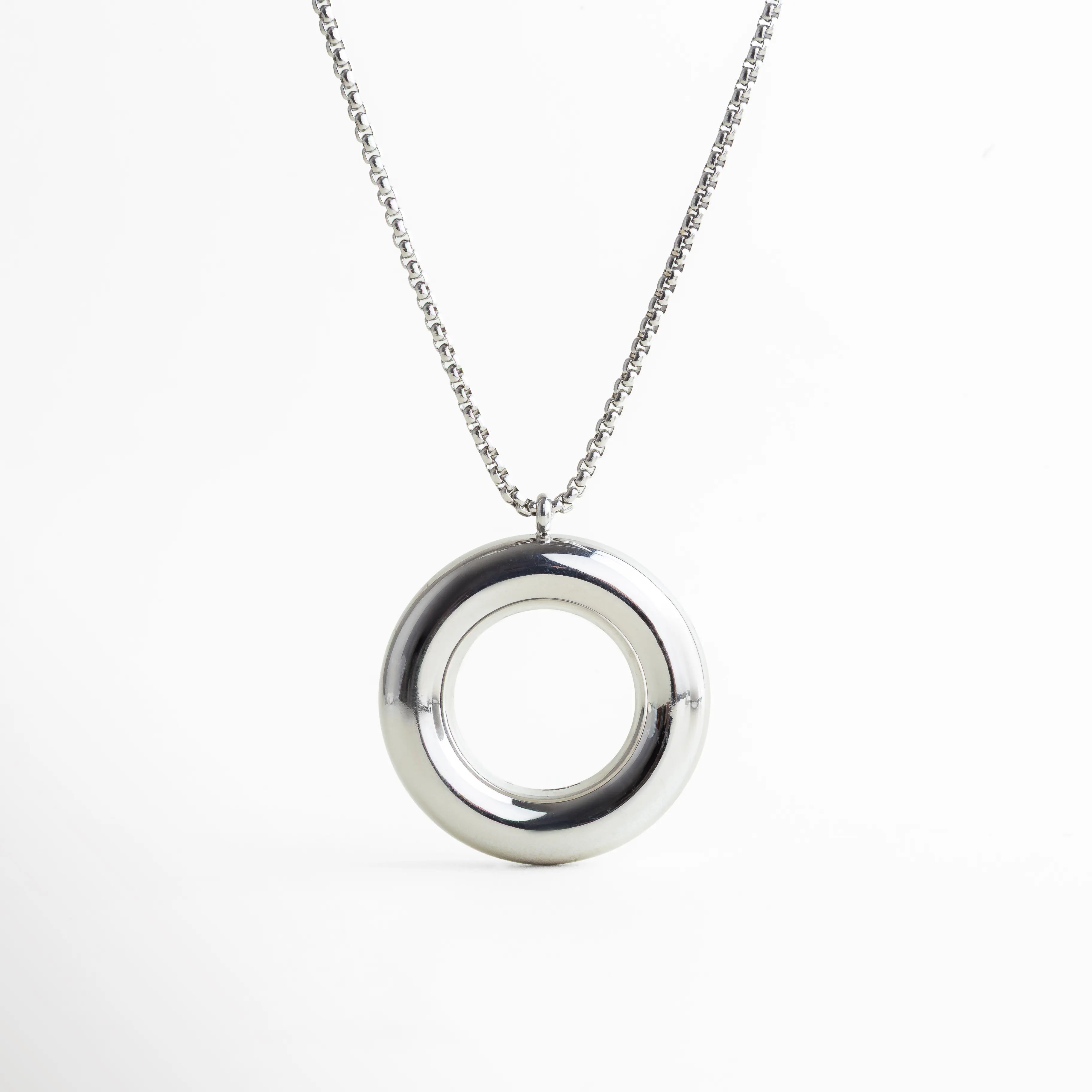 Collar plateado con dije circular suspendido, capturado en caída natural. Su forma refleja equilibrio y modernidad, perfecta para elevar atuendos sobrios con un toque artístico y contemporáneo.