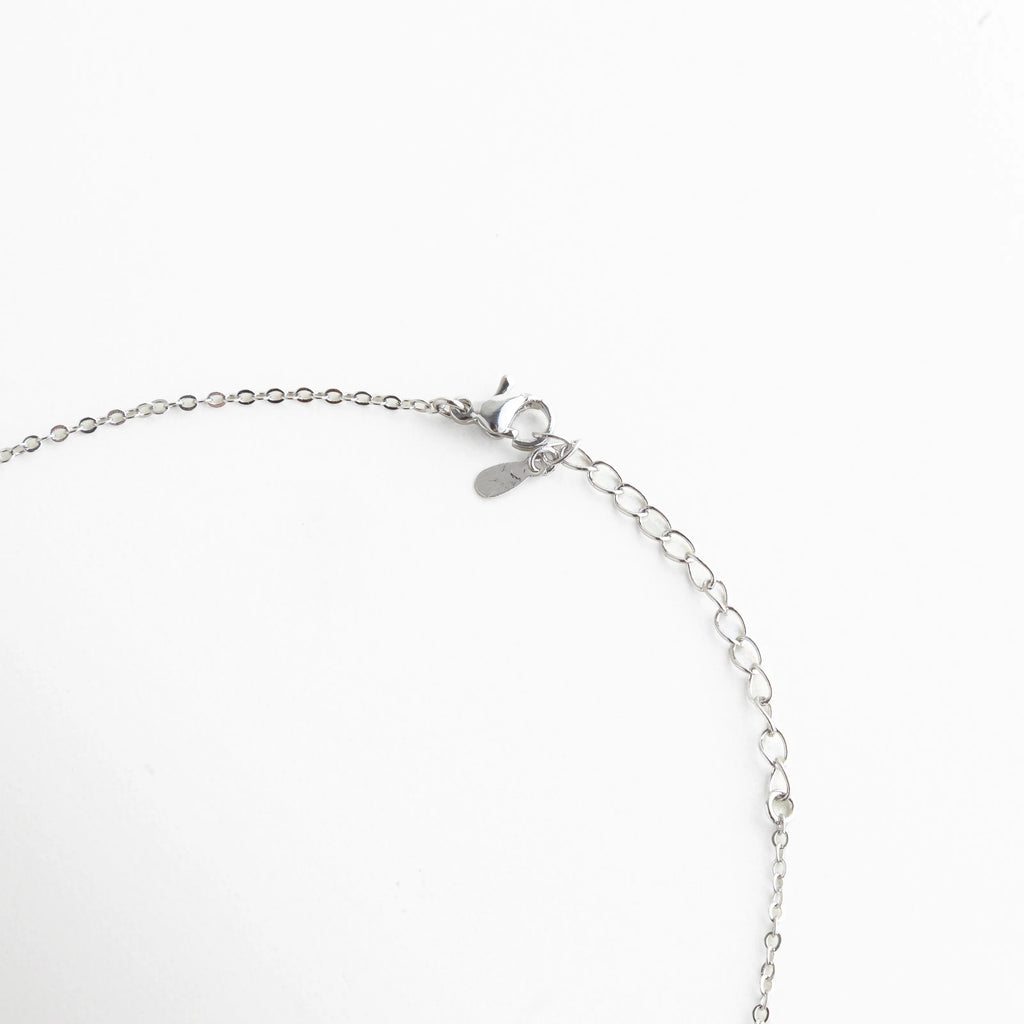 Cierre de langosta y cadena ajustable de 22+4 cm en collar de oro blanco, Detalle del extensor de 4 cm para ajustar largo de collar de bisutería, Acabado del broche seguro en collar de cobre con baño de oro blanco 18K, Extensión de cadena plateada para ajuste personalizado de collar elegante, Vista trasera del collar mostrando la calidad del cierre y eslabones de ajuste