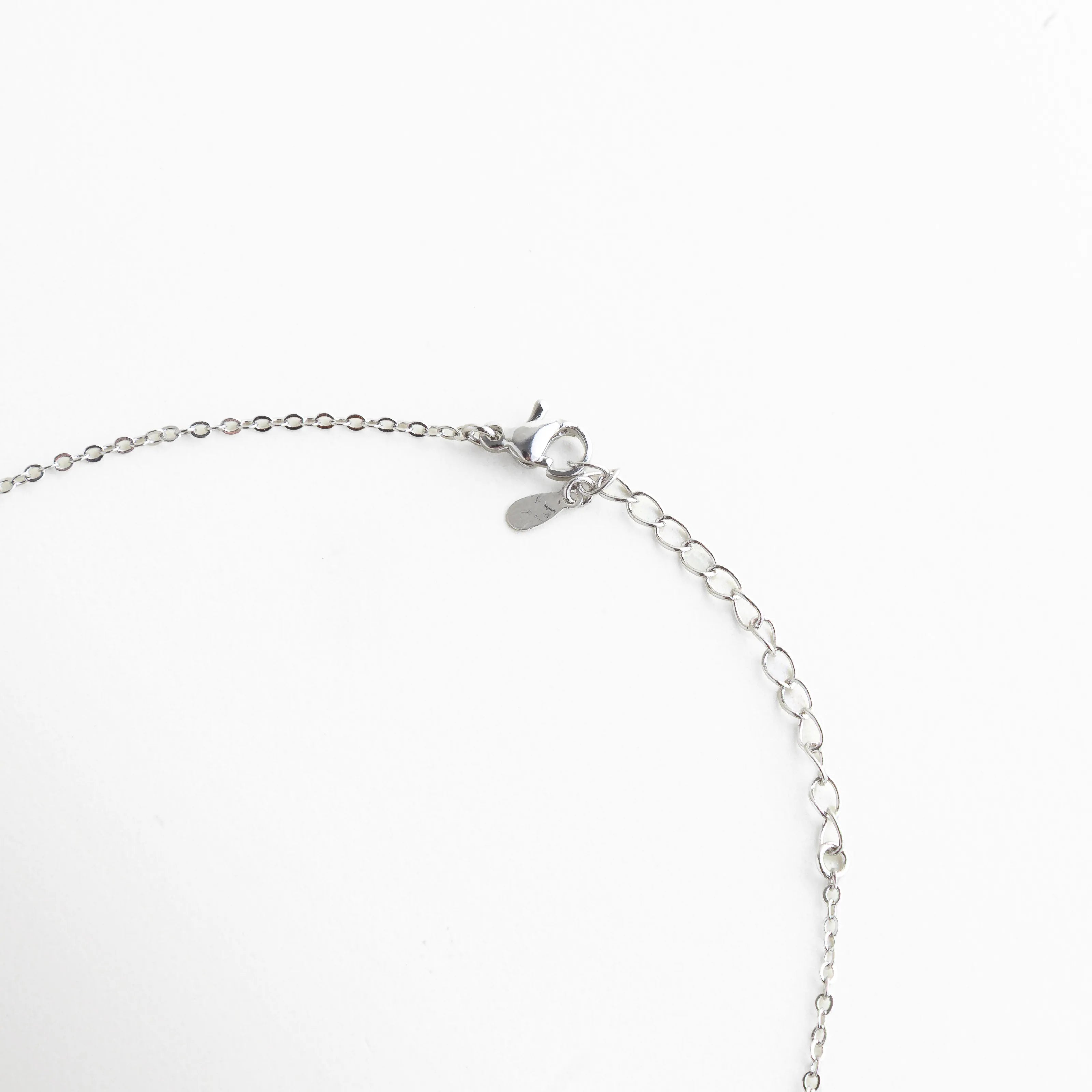 Cierre de langosta y cadena ajustable de 22+4 cm en collar de oro blanco, Detalle del extensor de 4 cm para ajustar largo de collar de bisutería, Acabado del broche seguro en collar de cobre con baño de oro blanco 18K, Extensión de cadena plateada para ajuste personalizado de collar elegante, Vista trasera del collar mostrando la calidad del cierre y eslabones de ajuste