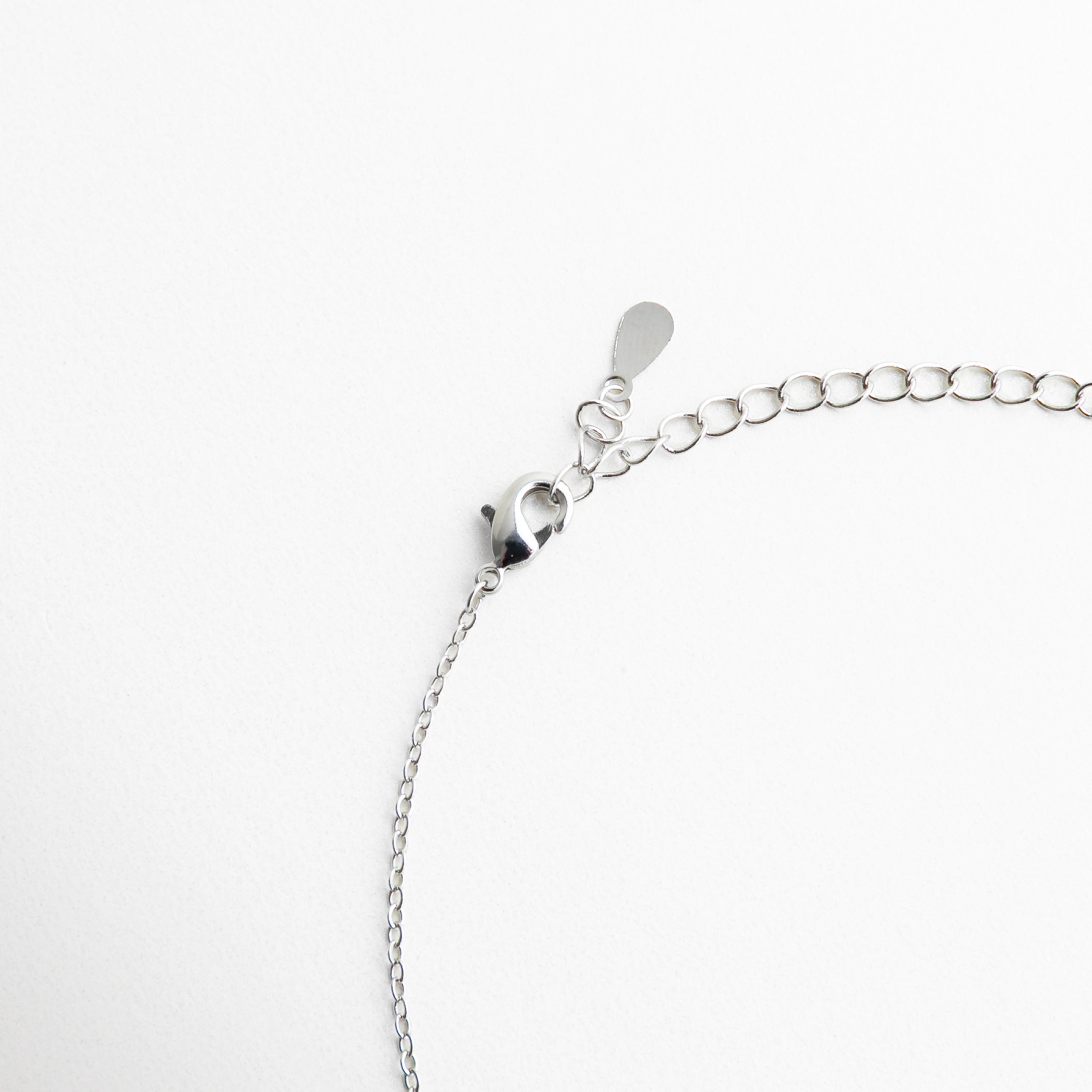 cierre tipo langosta en collar plateado, cadena ajustable de collar femenino, detalle de broche metálico en collar delicado, collar con extensión para ajuste de largo, sistema de cierre seguro en collar