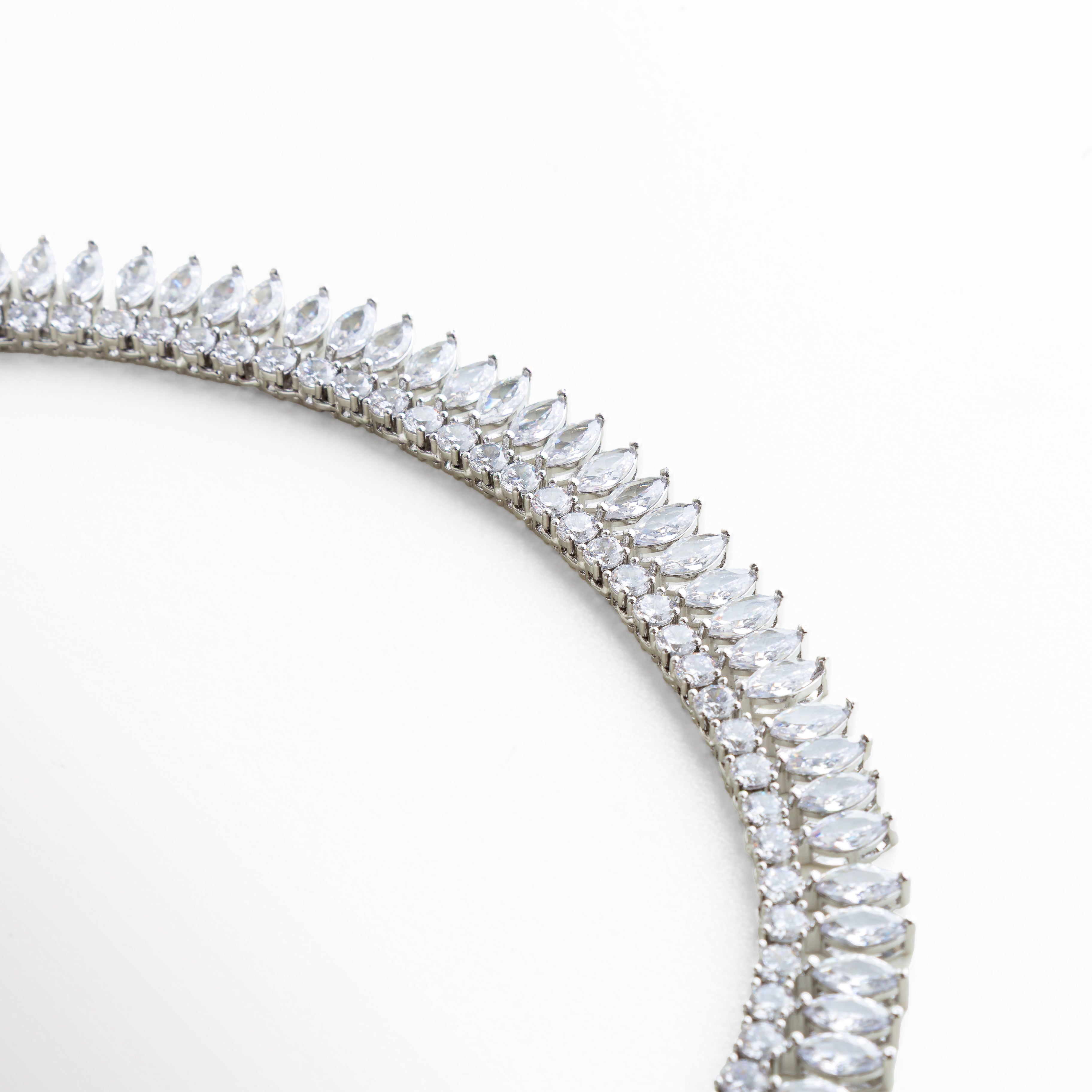 Detalle de zirconias engarzadas en forma de hoja, Close up de piedras brillantes con corte marquise, Joyería con acabado fino y engaste preciso, Detalle de collar con zirconias de alta luminosidad, Collar elegante con trabajo delicado en piedras