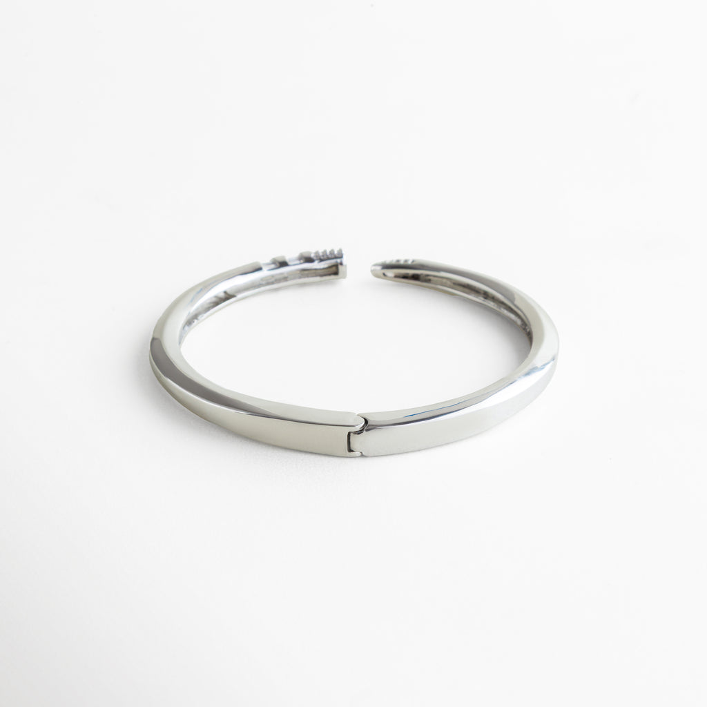 pulsera rígida abierta plateada diseño funcional, pulsera plateada sin broche diseño moderno, pulsera abierta de acero inoxidable plateado, pulsera rígida fácil de colocar, joyería plateada de diseño estructurado