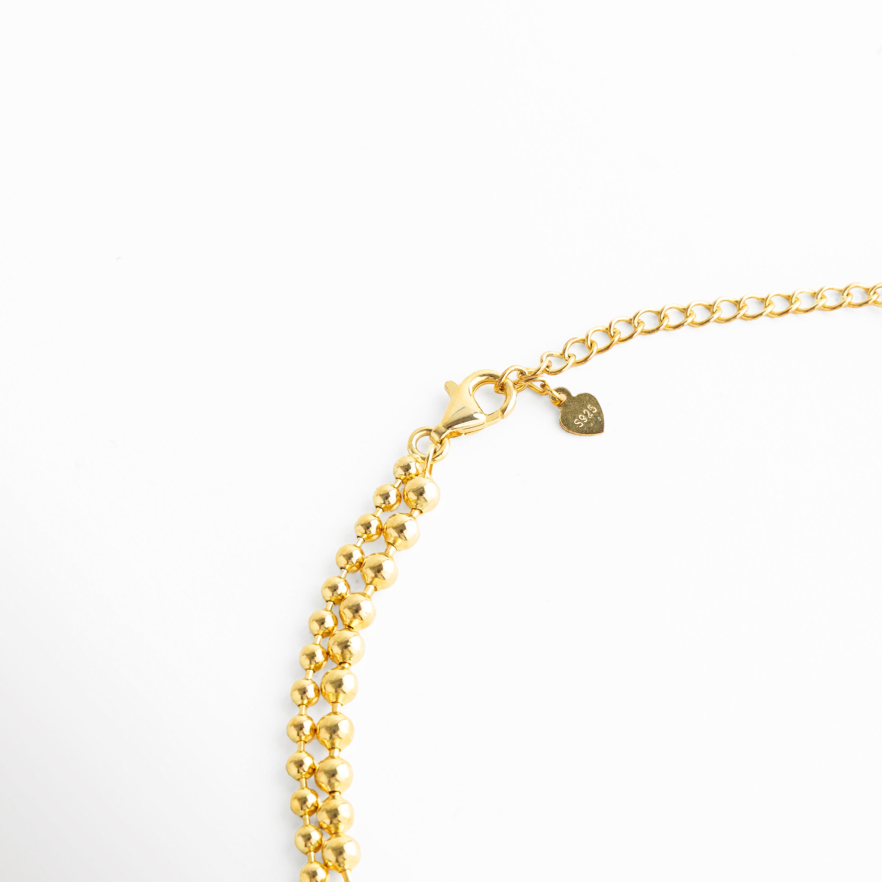 detalle de eslabones finos en collar dorado, cadena dorada con zirconias detalle cercano, textura delicada collar dorado fino, detalle de diseño collar dorado minimal, collar de joyería fina detalle de cadena