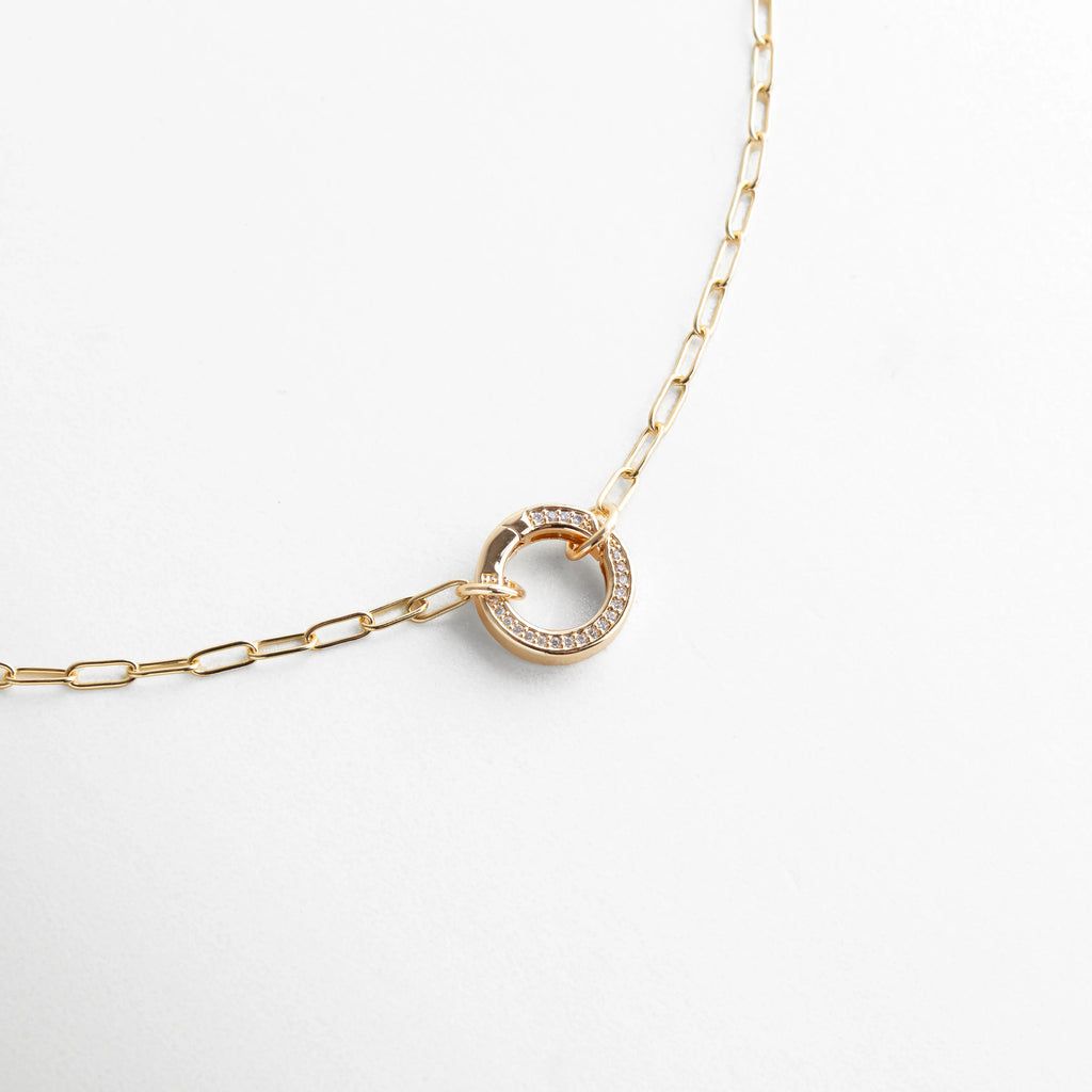 Collar dorado con cadena de eslabones finos y dije circular con incrustaciones de zirconias, un diseño elegante y atemporal.